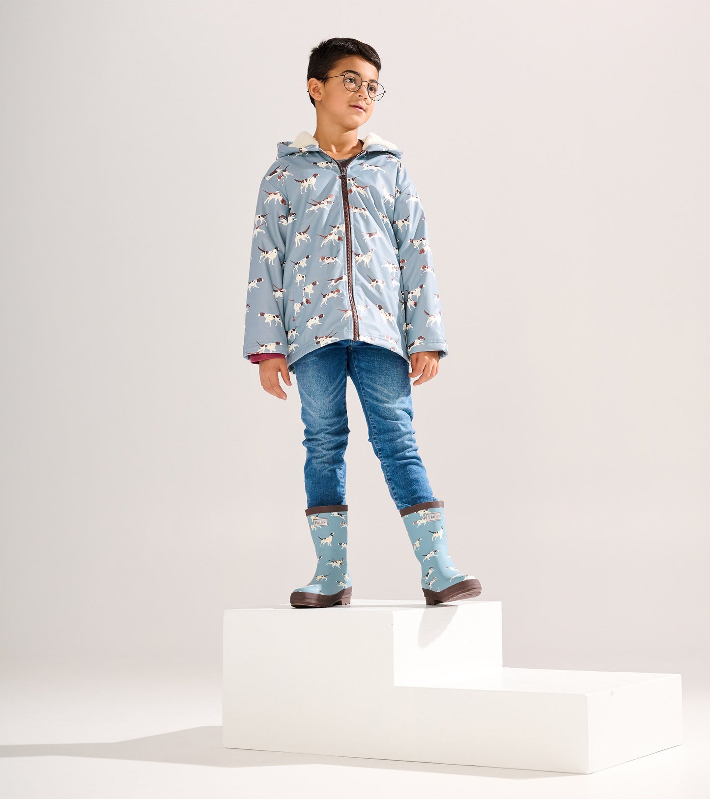 Matte blue rain boots with hunting dog pattern, featuring a brown sole, suitable for boys.