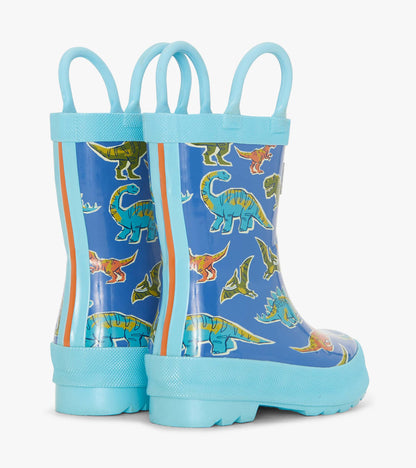 Blue rain boots featuring colorful dinosaur patterns, with two handles for easy wear.