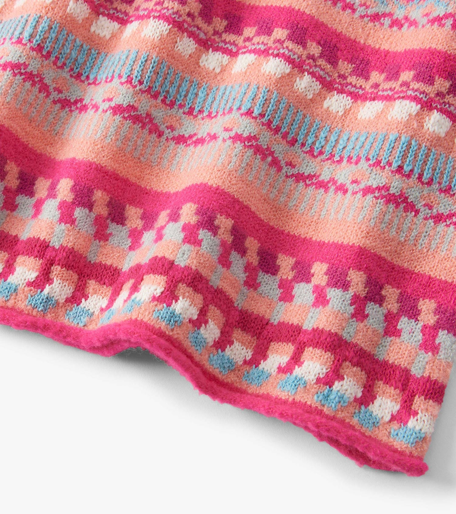 Colorful sweater dress featuring sunset stripes in pink, peach, and blue with a cozy knit texture.