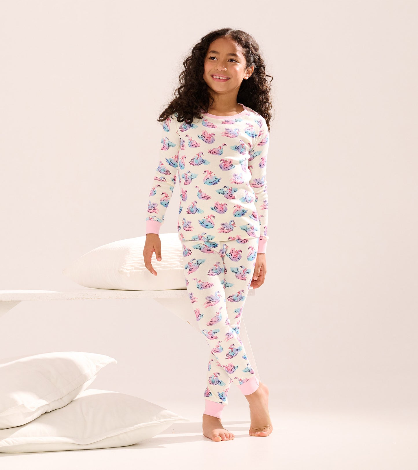 Girls' cotton pajama set featuring a pastel swan pattern, long sleeves, and pink cuffs, suitable for sleepwear.