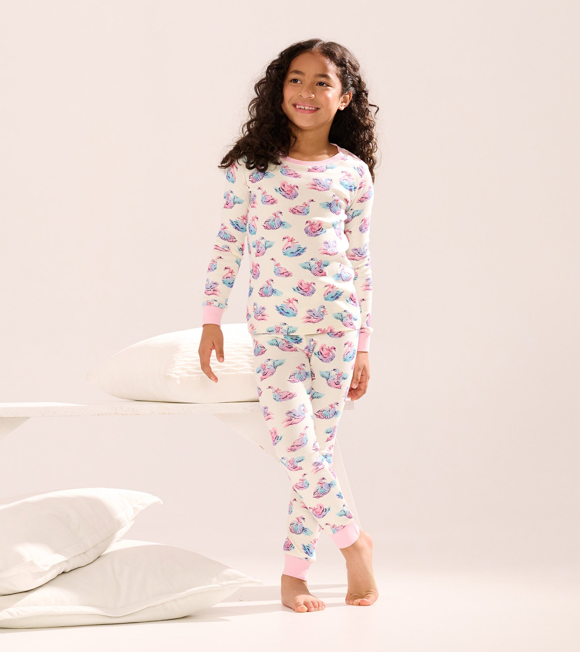 Girls' cotton pajama set featuring a pastel swan pattern, long sleeves, and pink cuffs, suitable for sleepwear.