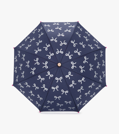 Navy umbrella with white ribbon patterns and pink tips, featuring an octagonal shape for rain protection.