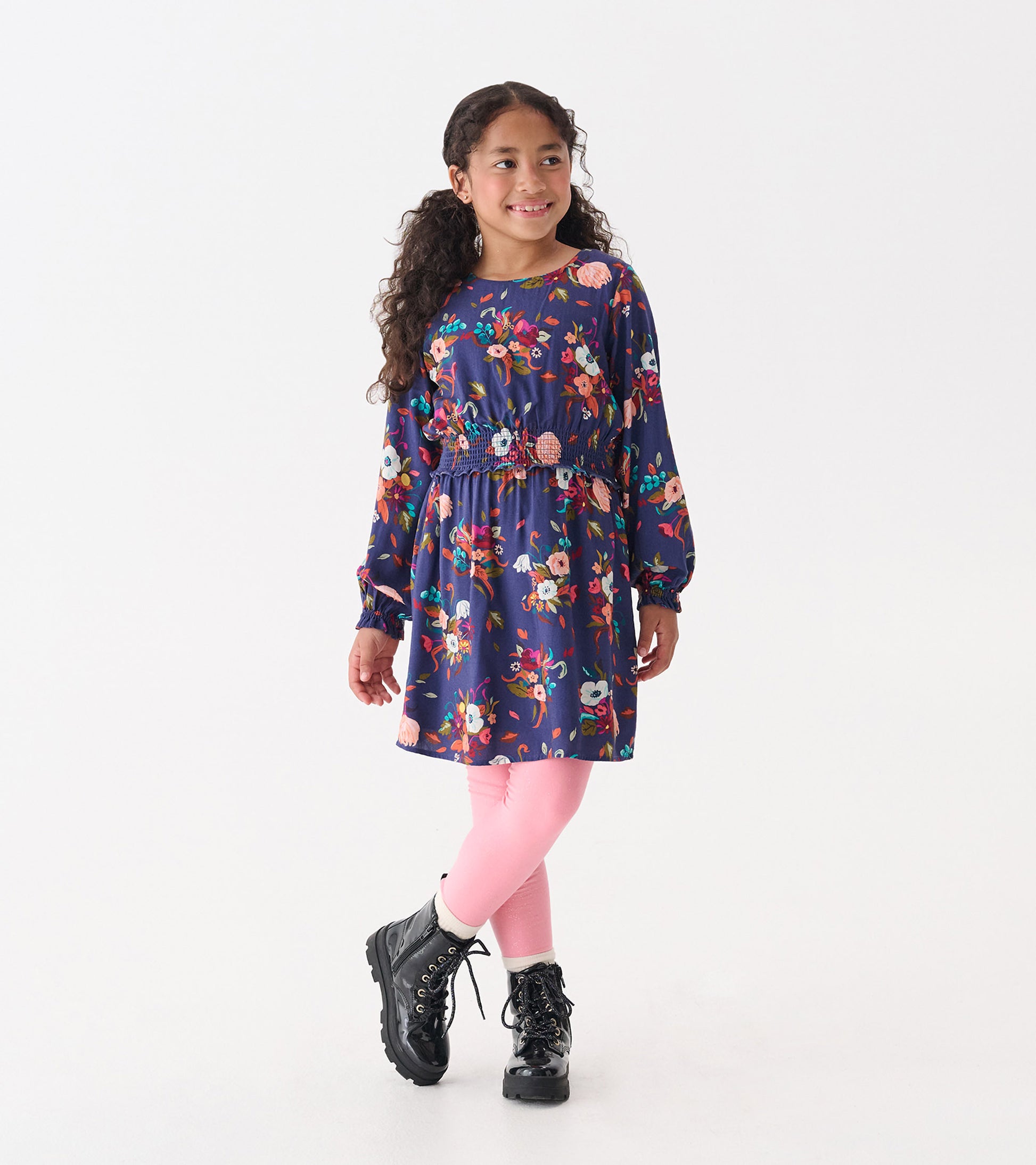 Navy floral dress with long sleeves, smocked waist, paired with pink leggings and black boots, suitable for special events.