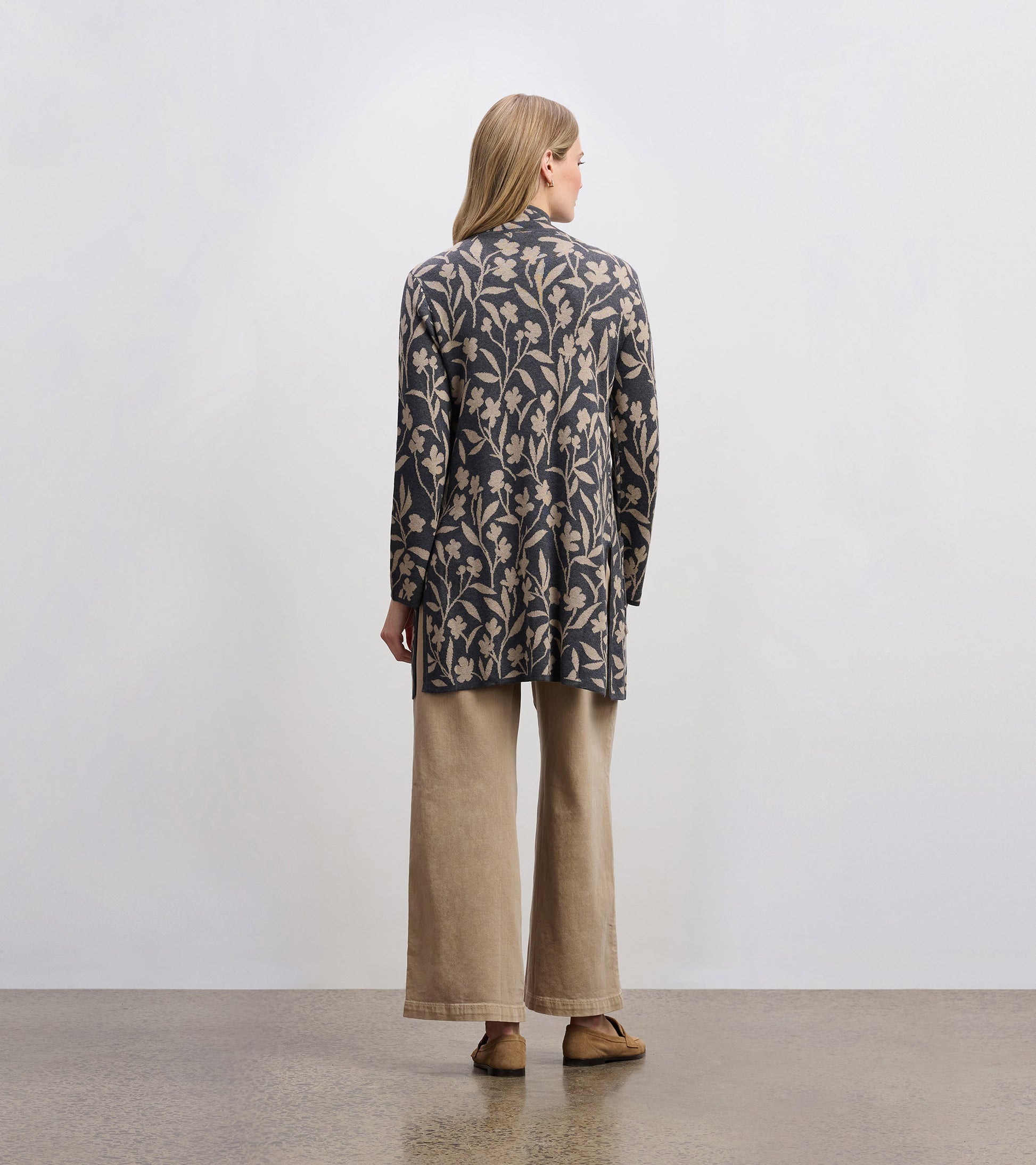 Long-sleeve sweater blazer with floral vine pattern in navy and beige, styled with wide-leg pants.