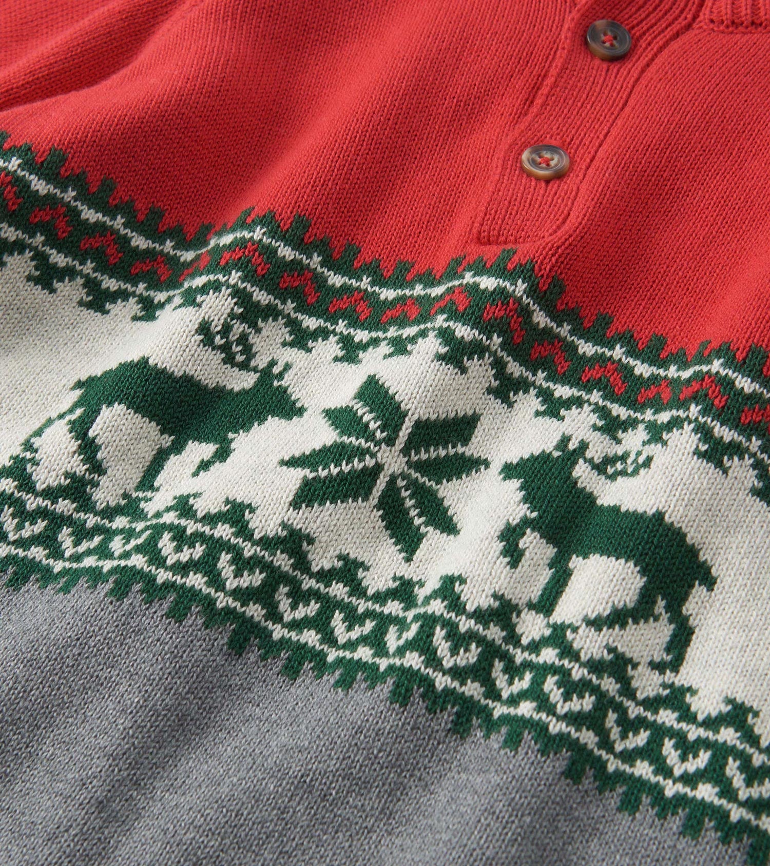 Red mockneck sweater featuring a festive elk and snowflake pattern in green and white, with gray lower section.