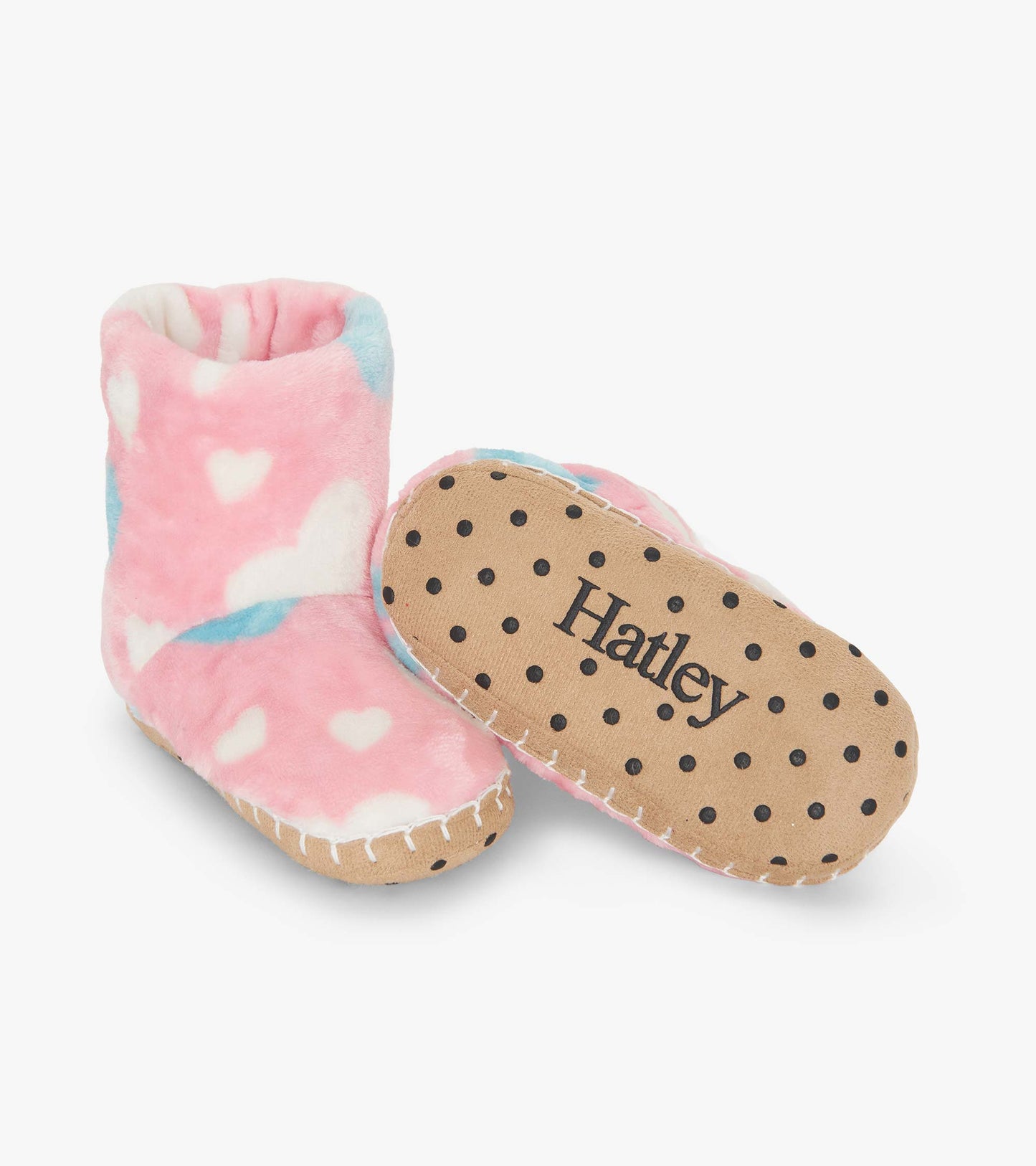 Pink fuzzy fleece slippers with white hearts and blue accents, featuring a polka dot sole for grip.