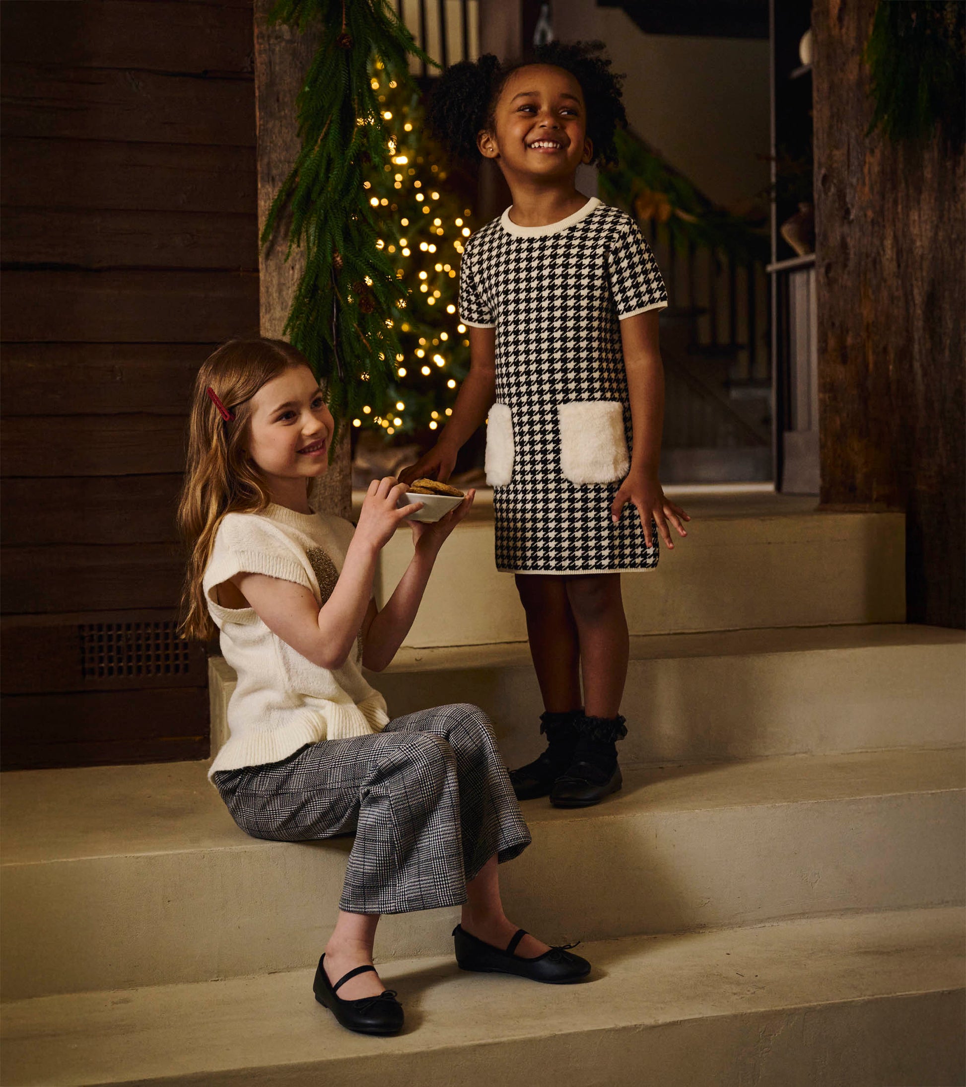 Girls black-and-white houndstooth sweater dress with white faux fur pockets, short sleeves, and crew neck