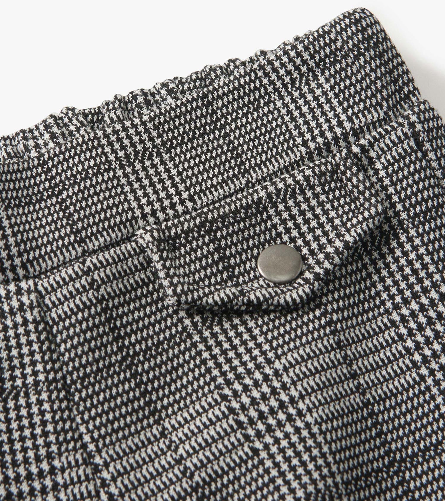 Black and white houndstooth plaid wide leg pants with an elastic waistband and a snap button detail.