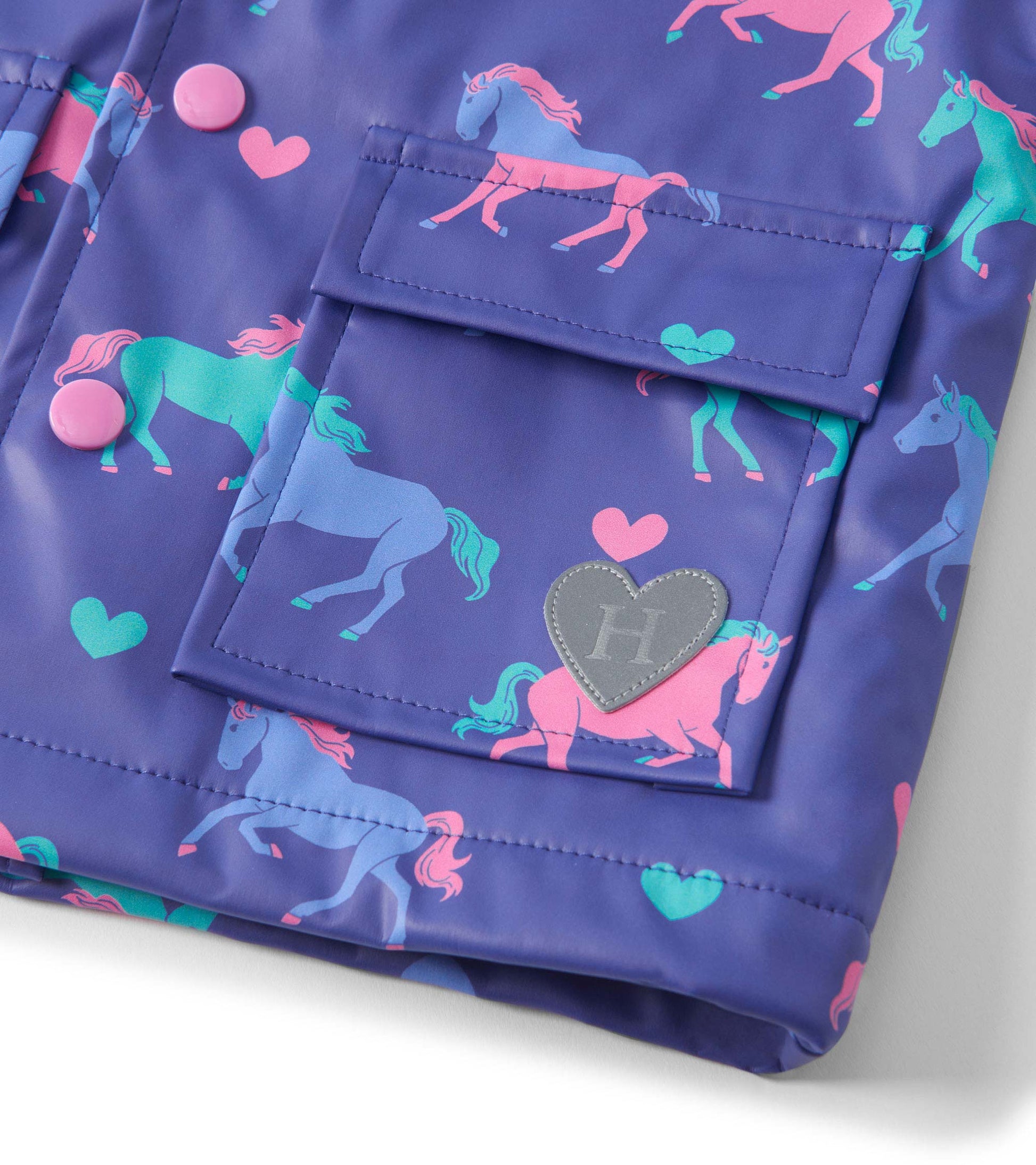 Purple rain jacket featuring colorful horse and heart patterns, with pink buttons and a heart-shaped logo patch.