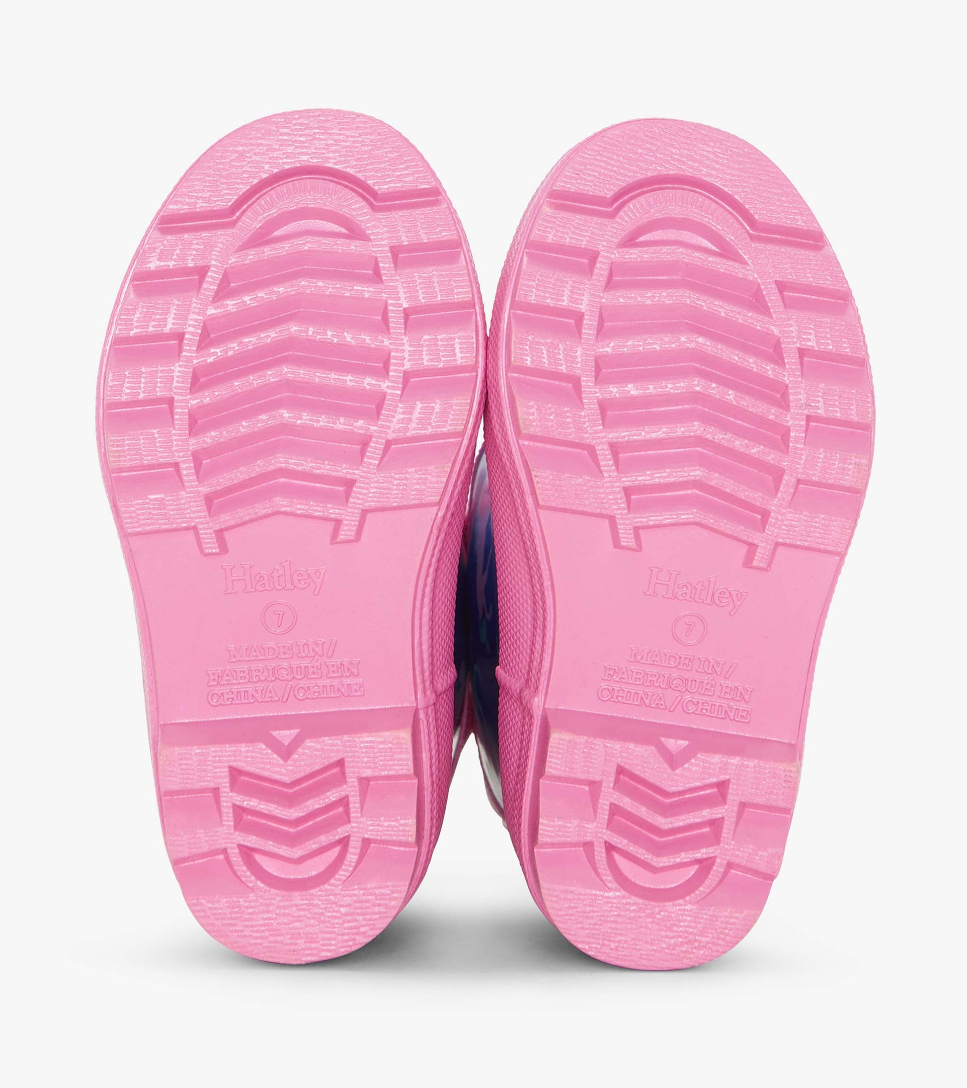 Pink rubber rain boots with textured soles, featuring a colorful hearts and horses pattern.