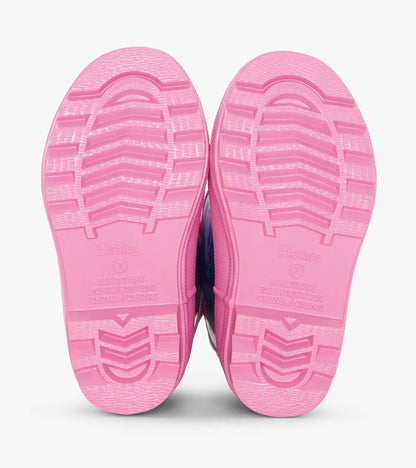 Pink rubber rain boots with textured soles, featuring a colorful hearts and horses pattern.