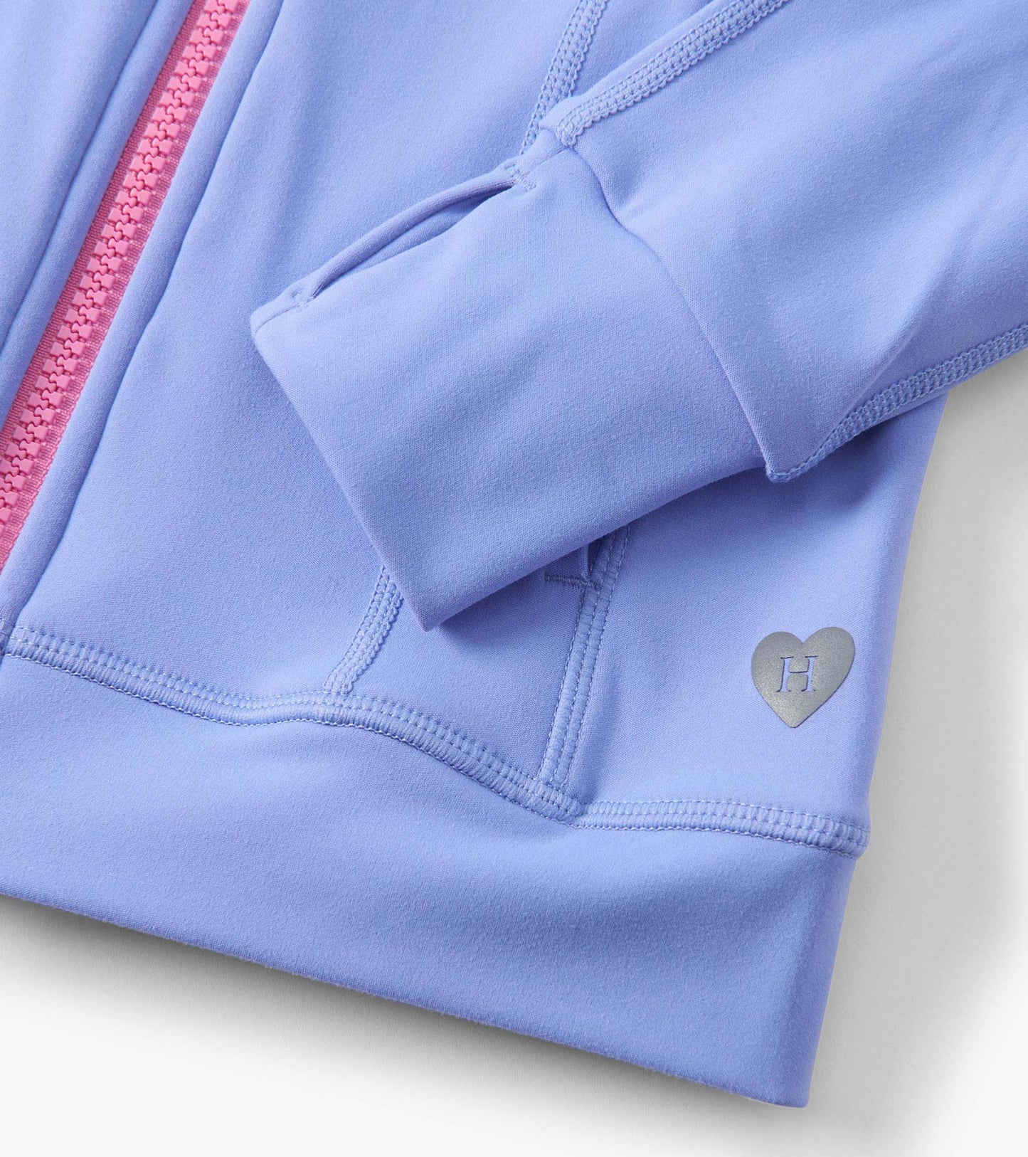 Lavender active jacket with pink zipper, featuring a heart logo and soft, stretchy fabric for comfort and movement.