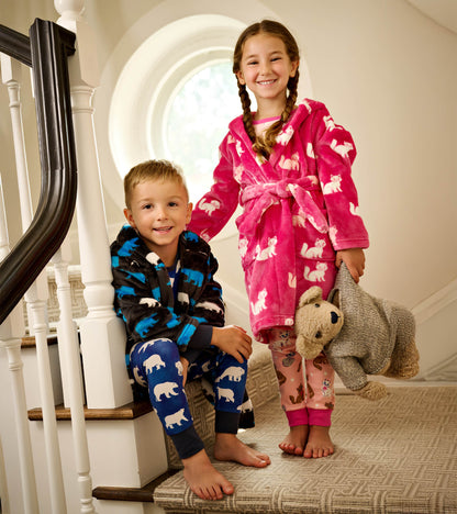 Fuzzy fleece robe in pink with white kittens, worn by a girl, paired with a boy in a black robe with blue bears.