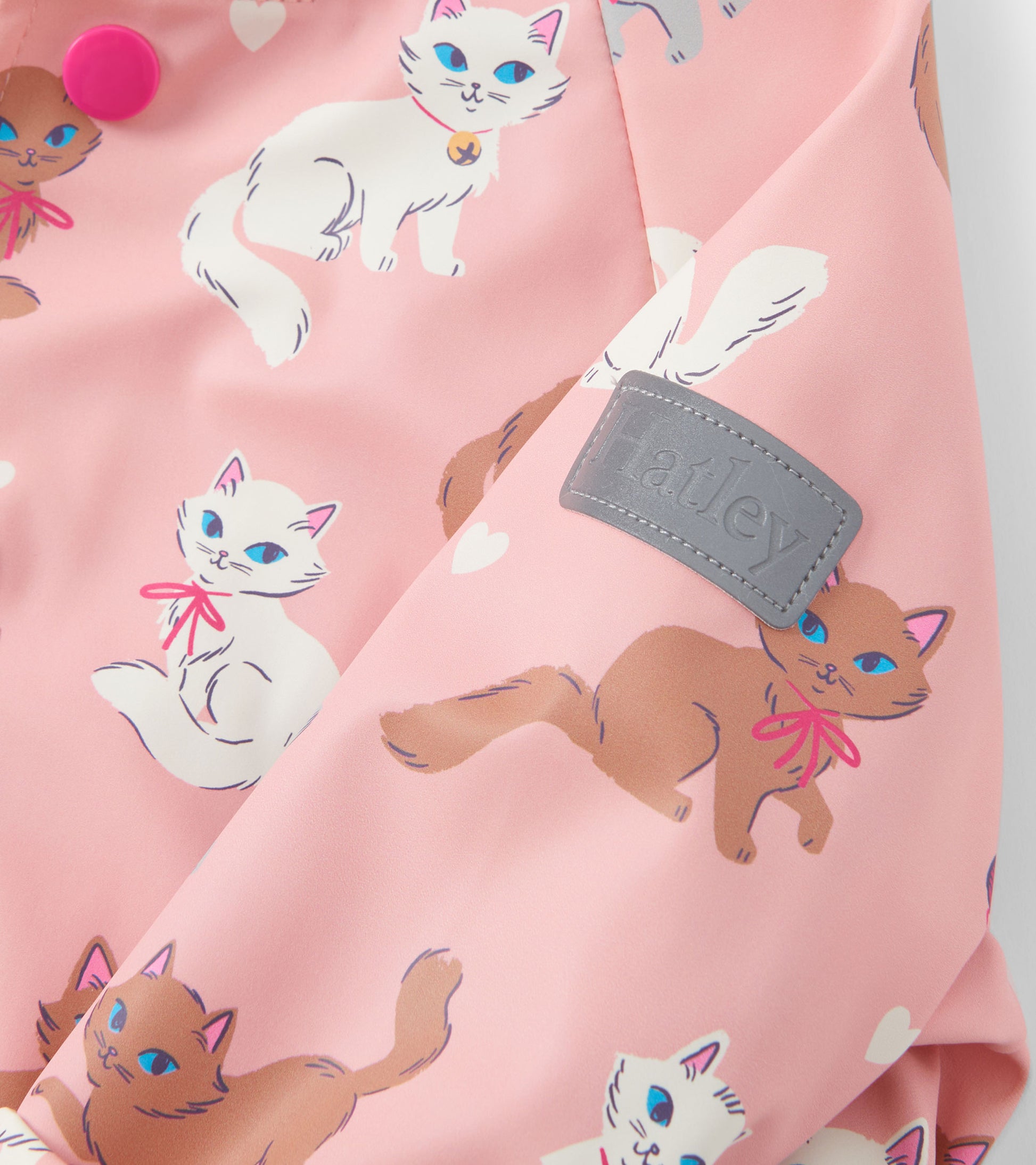 Pink rain jacket featuring playful kitty illustrations and a button closure. Ideal for baby and toddler girls.