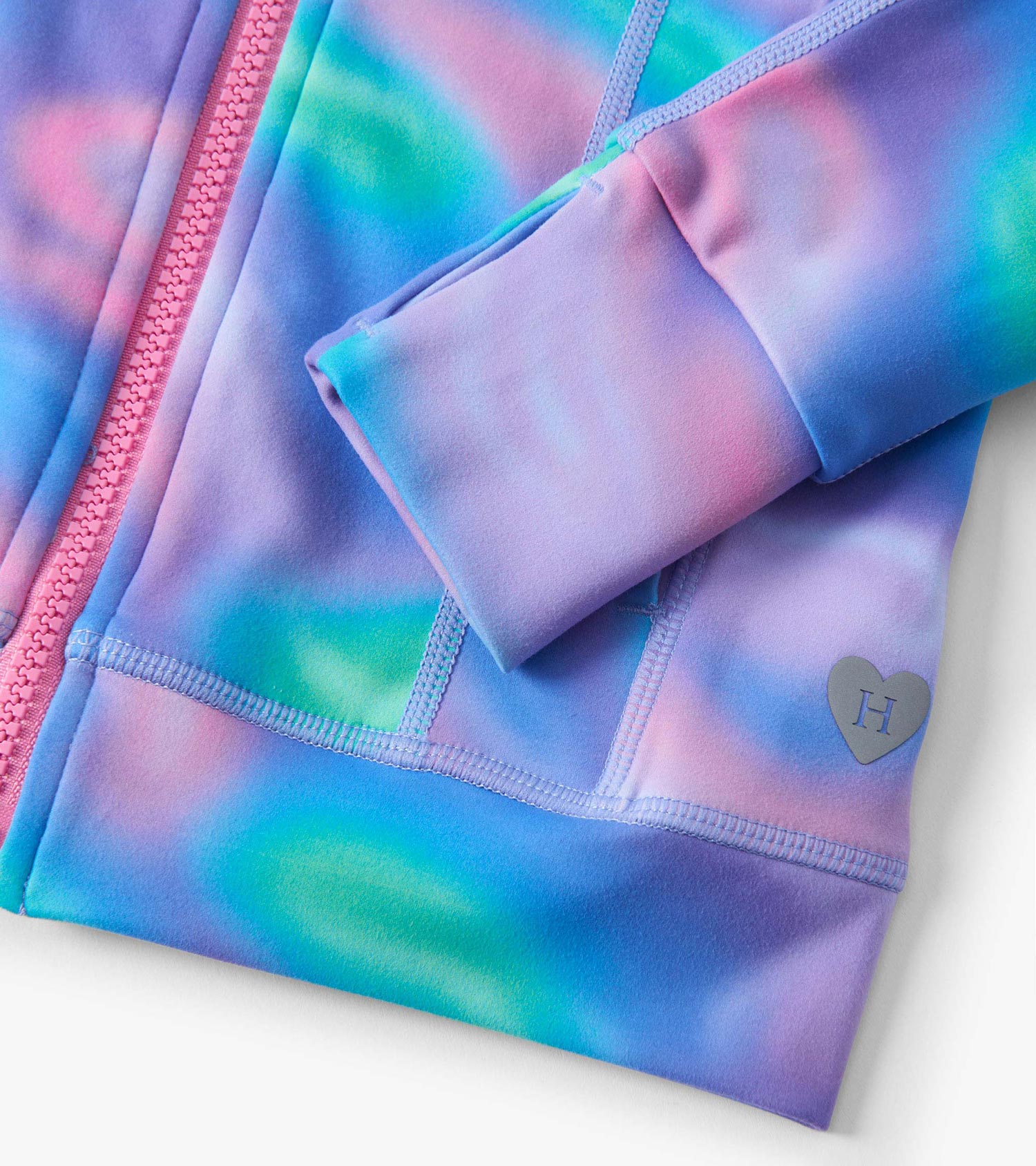 Purple and blue tie-dye active jacket with a pink zipper and heart logo detail on the sleeve.