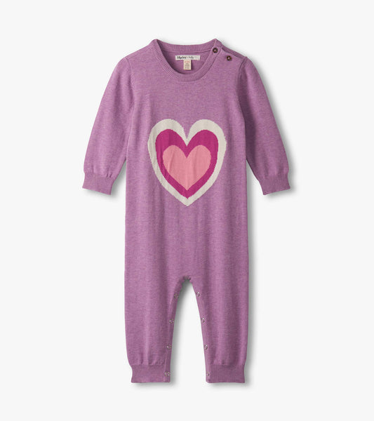 Purple sweater romper featuring a large heart design in pink tones, with long sleeves and snap closures at the bottom.