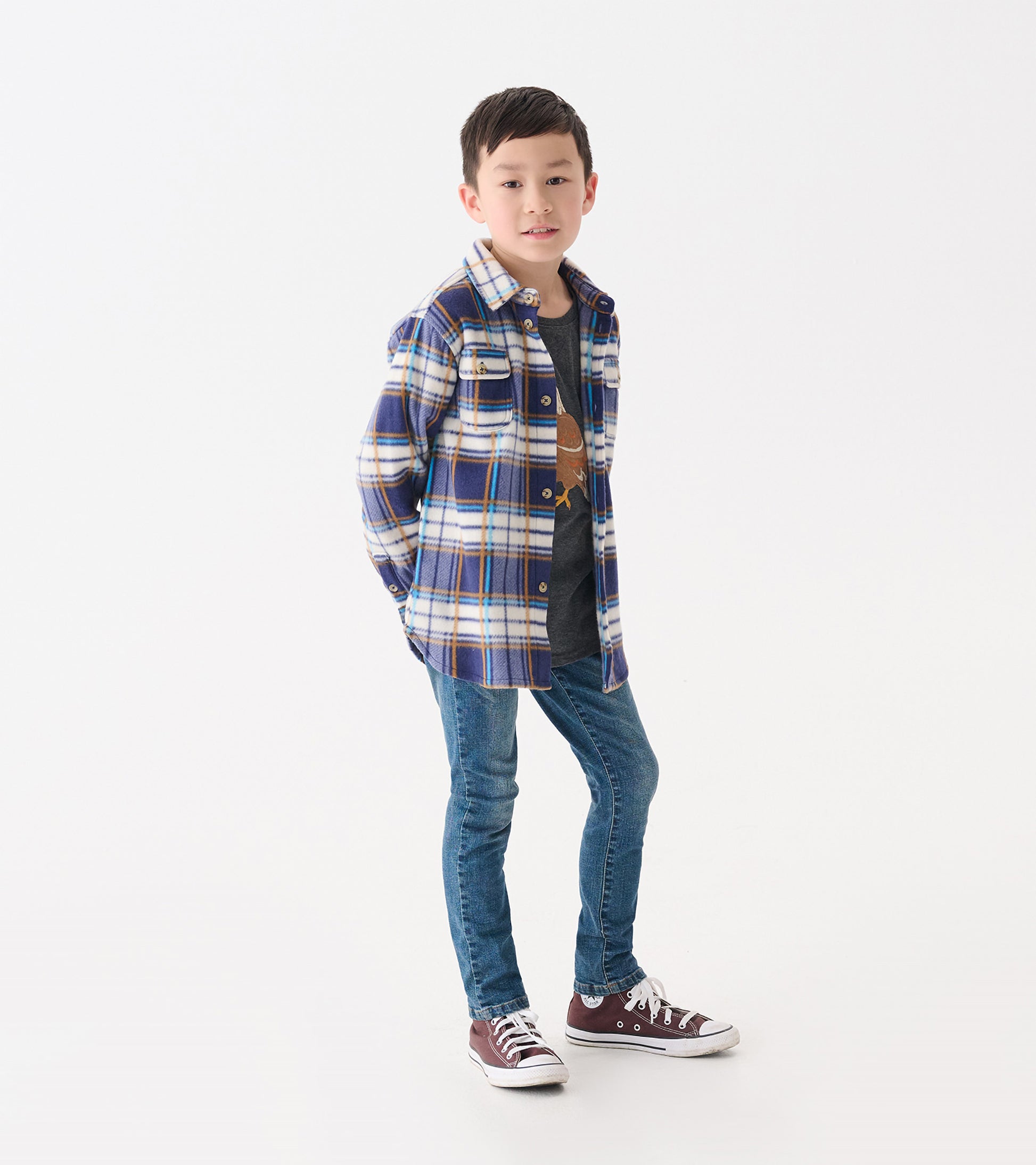 Blue and white plaid fleece button-up shirt on a boy, paired with a gray tee and jeans, standing casually.