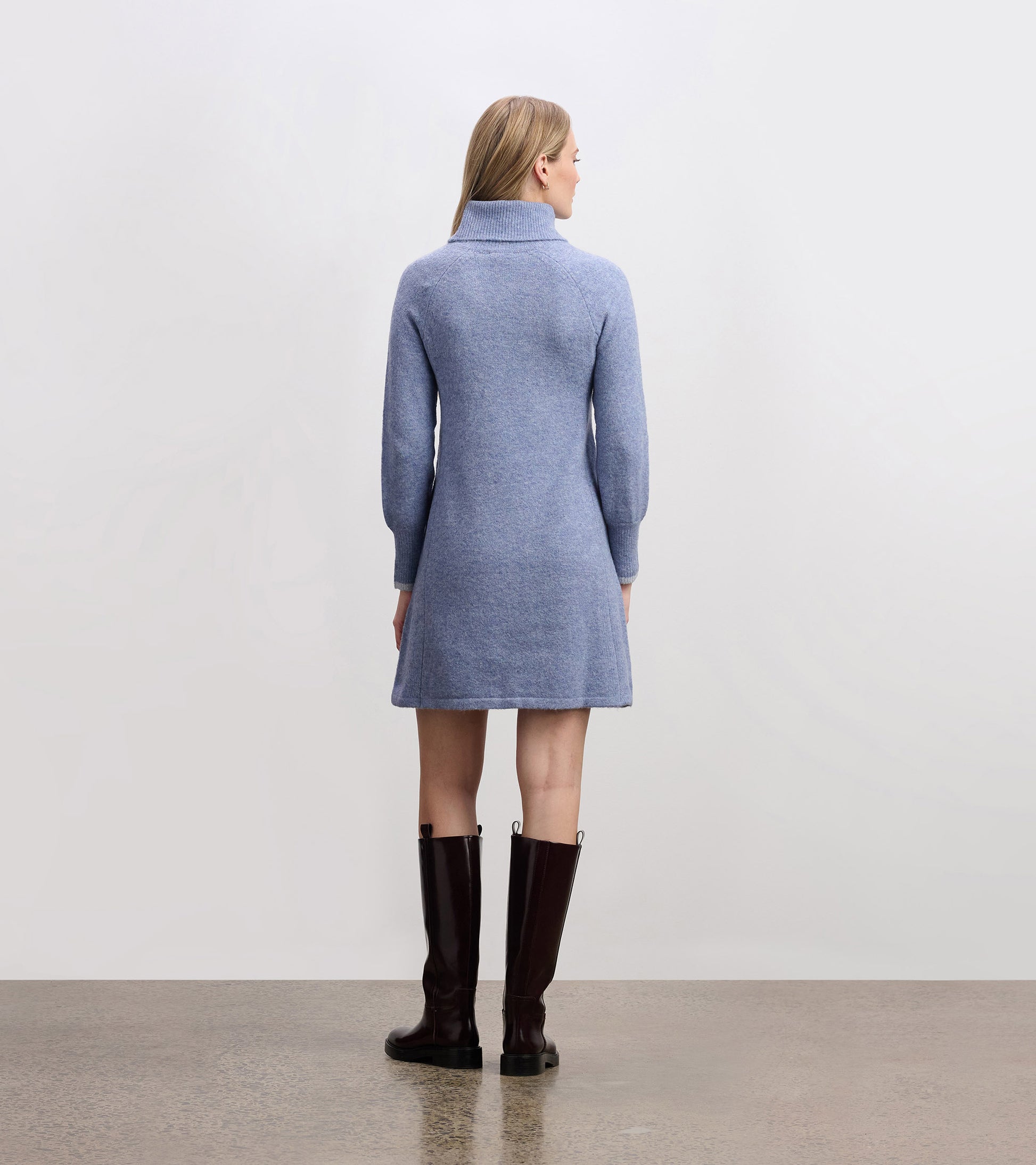 Light denim sweater dress with a high collar and long sleeves, featuring a relaxed fit and above-the-knee length.