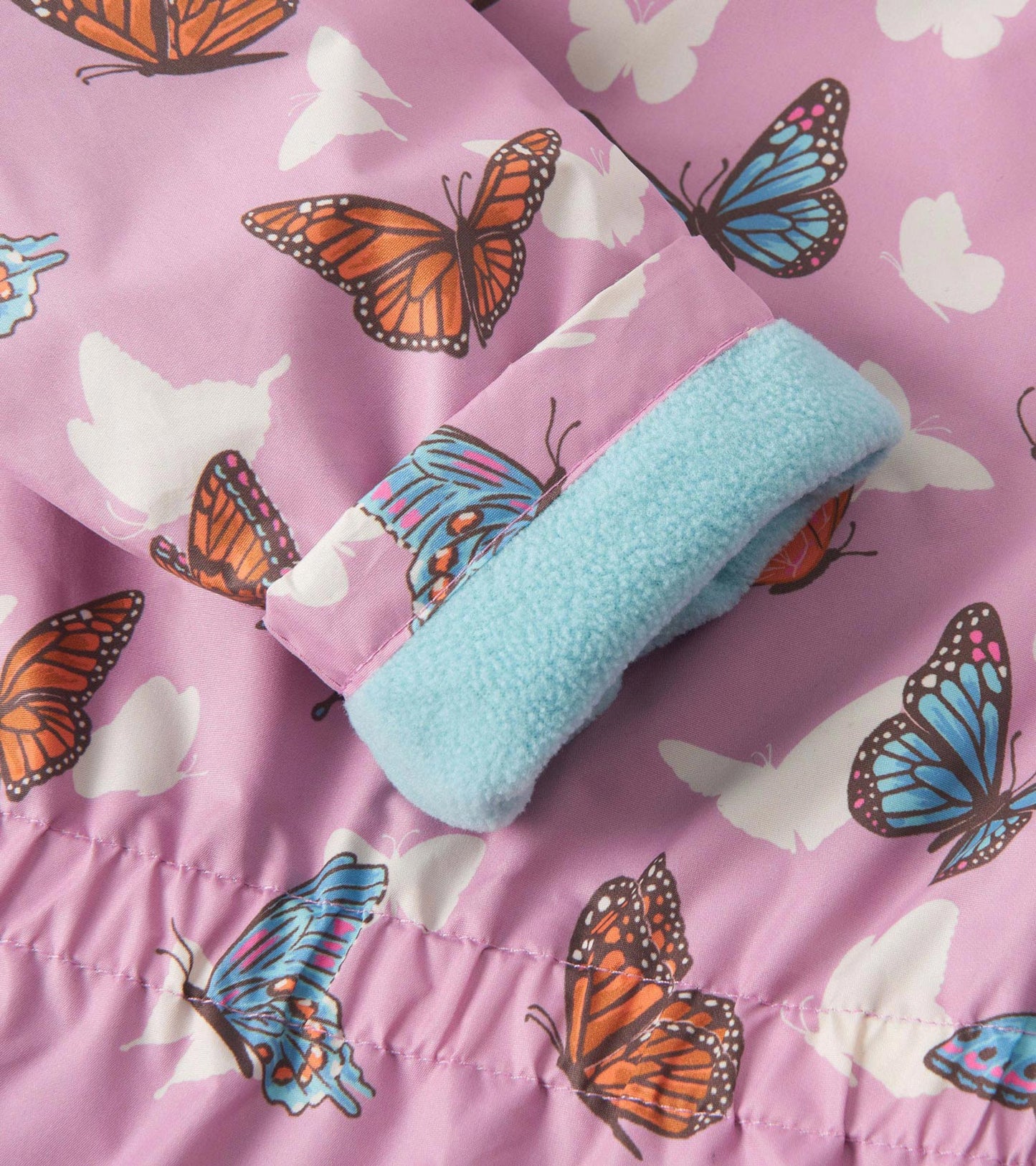 Lightweight zip-up rain jacket in pink with colorful butterfly patterns and a soft blue fleece lining at the cuffs.
