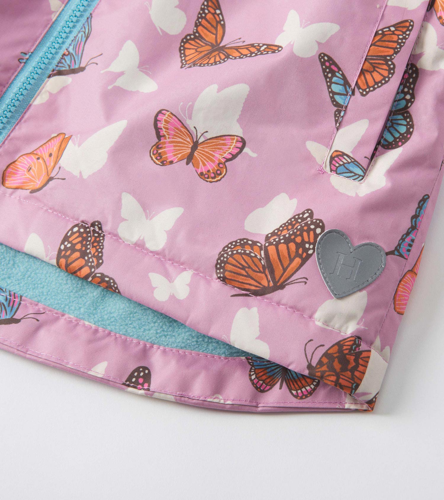 Lightweight zip-up rain jacket in pink with colorful butterfly print and a soft blue lining.