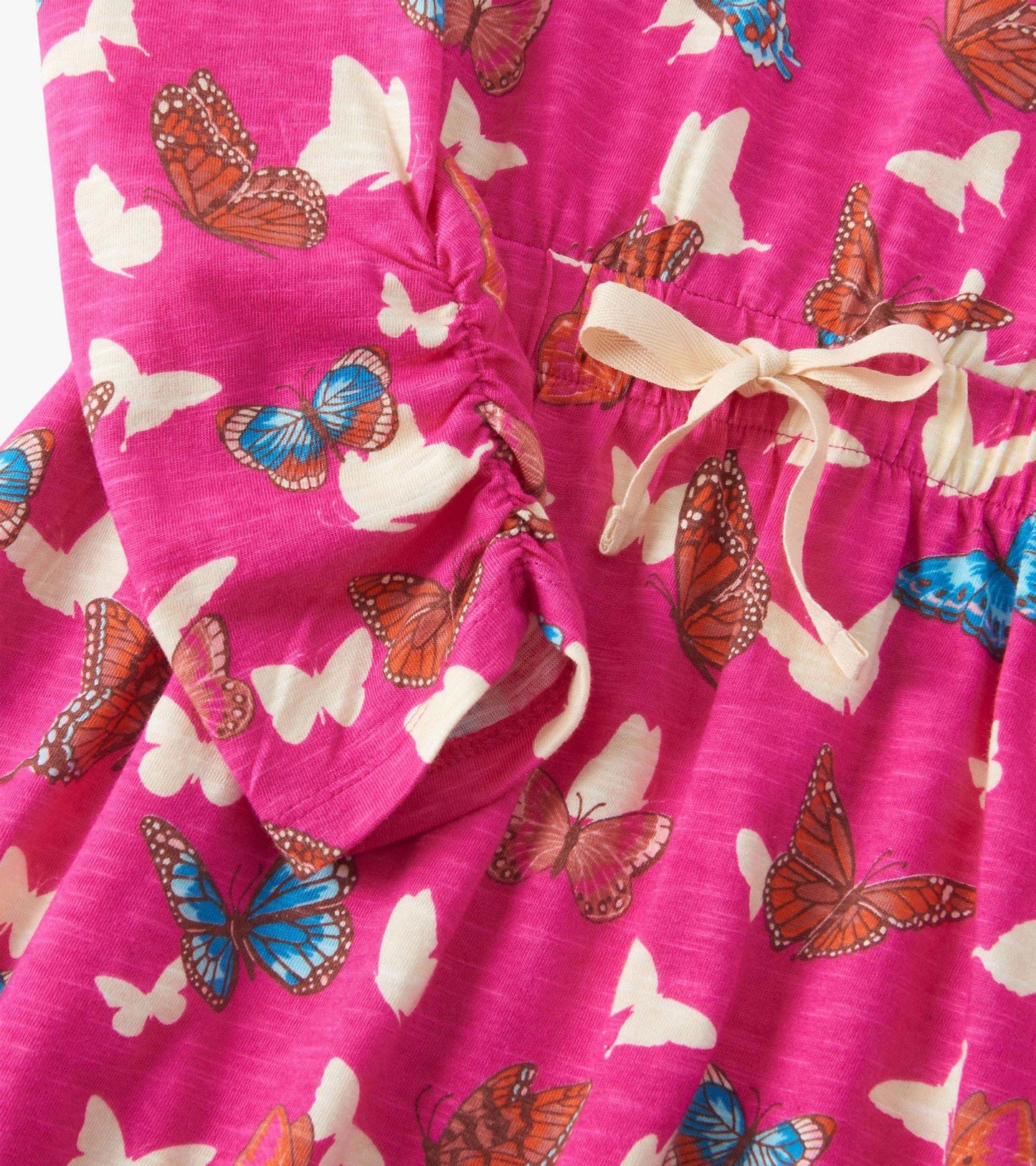 Pink dress featuring a cinched waist and a butterfly print in various colors, with a tied detail at the waist.