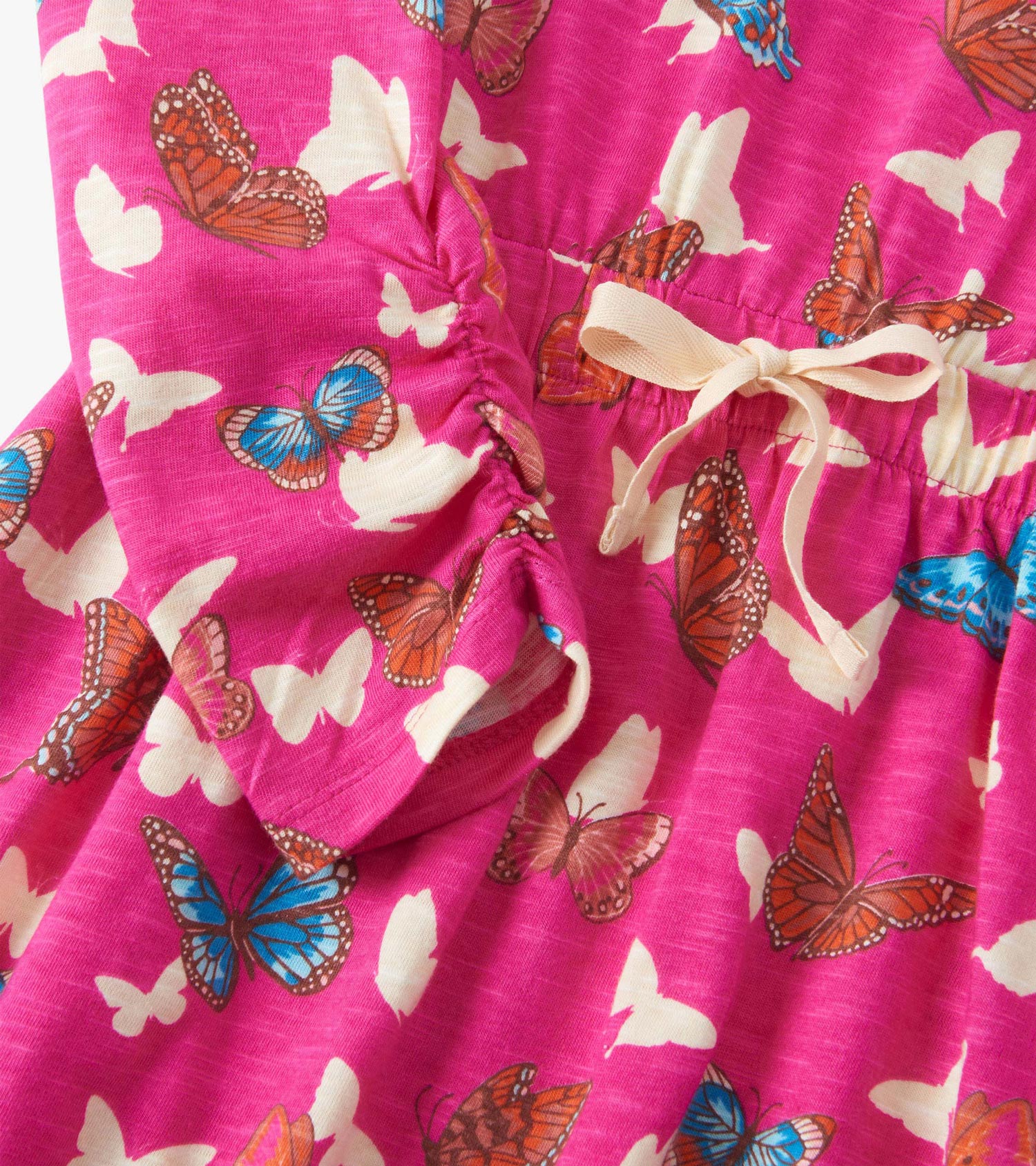 Pink dress featuring a cinched waist and a butterfly print in various colors, with a tied detail at the waist.