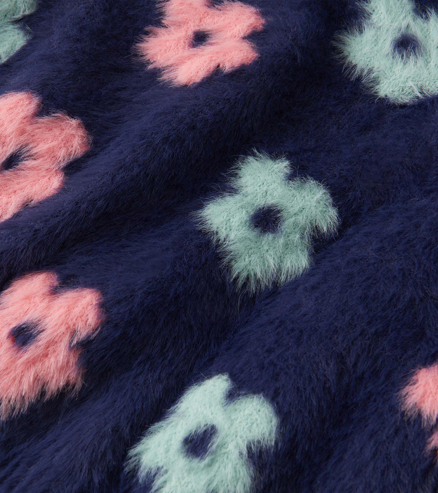 Navy cardigan featuring soft, fluffy fabric with pink and mint green flower patterns. Ideal for layering in cooler weather.
