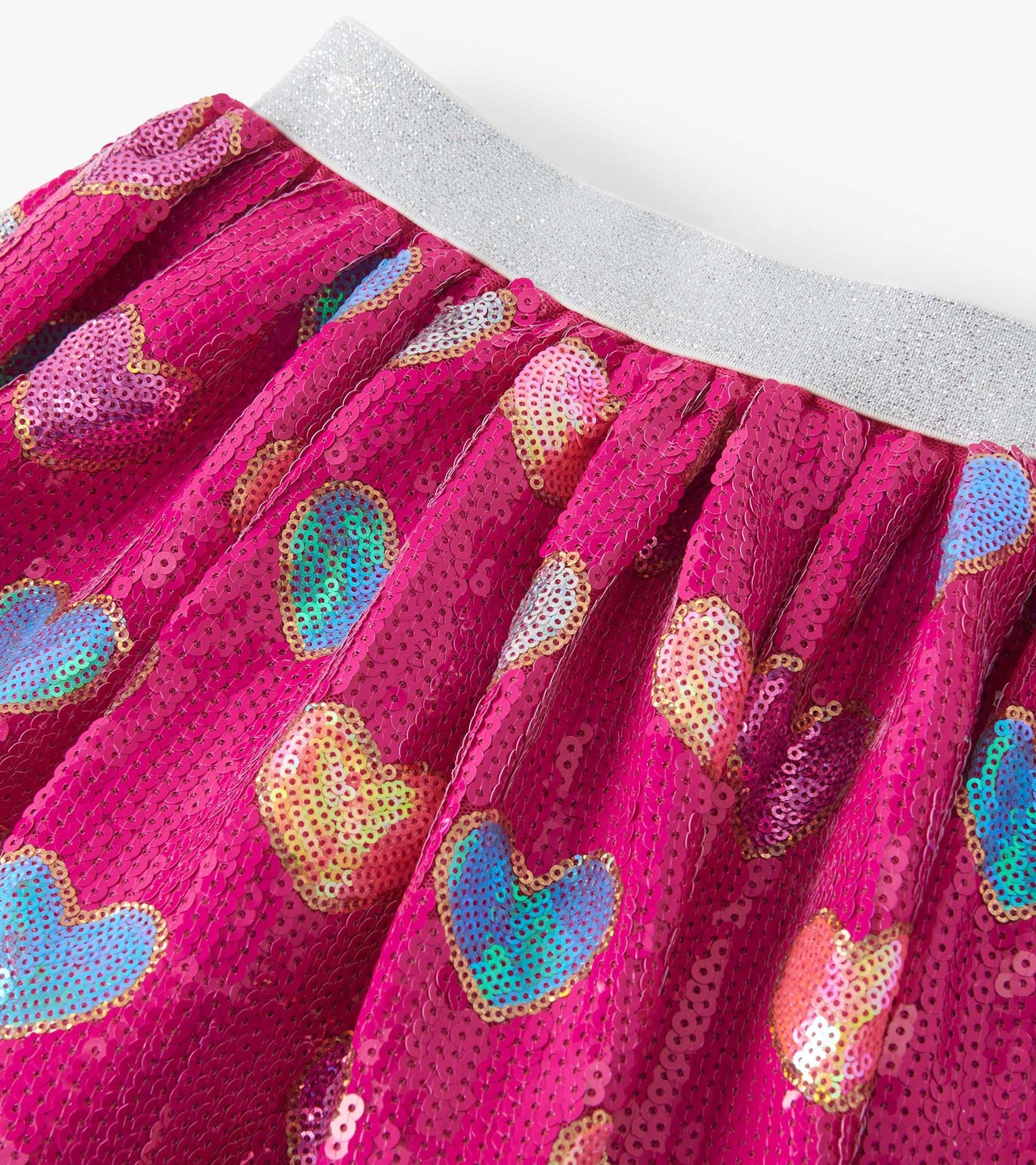 Pink sequin skirt featuring colorful heart patterns and a shiny silver waistband. Ideal for playful, festive occasions.