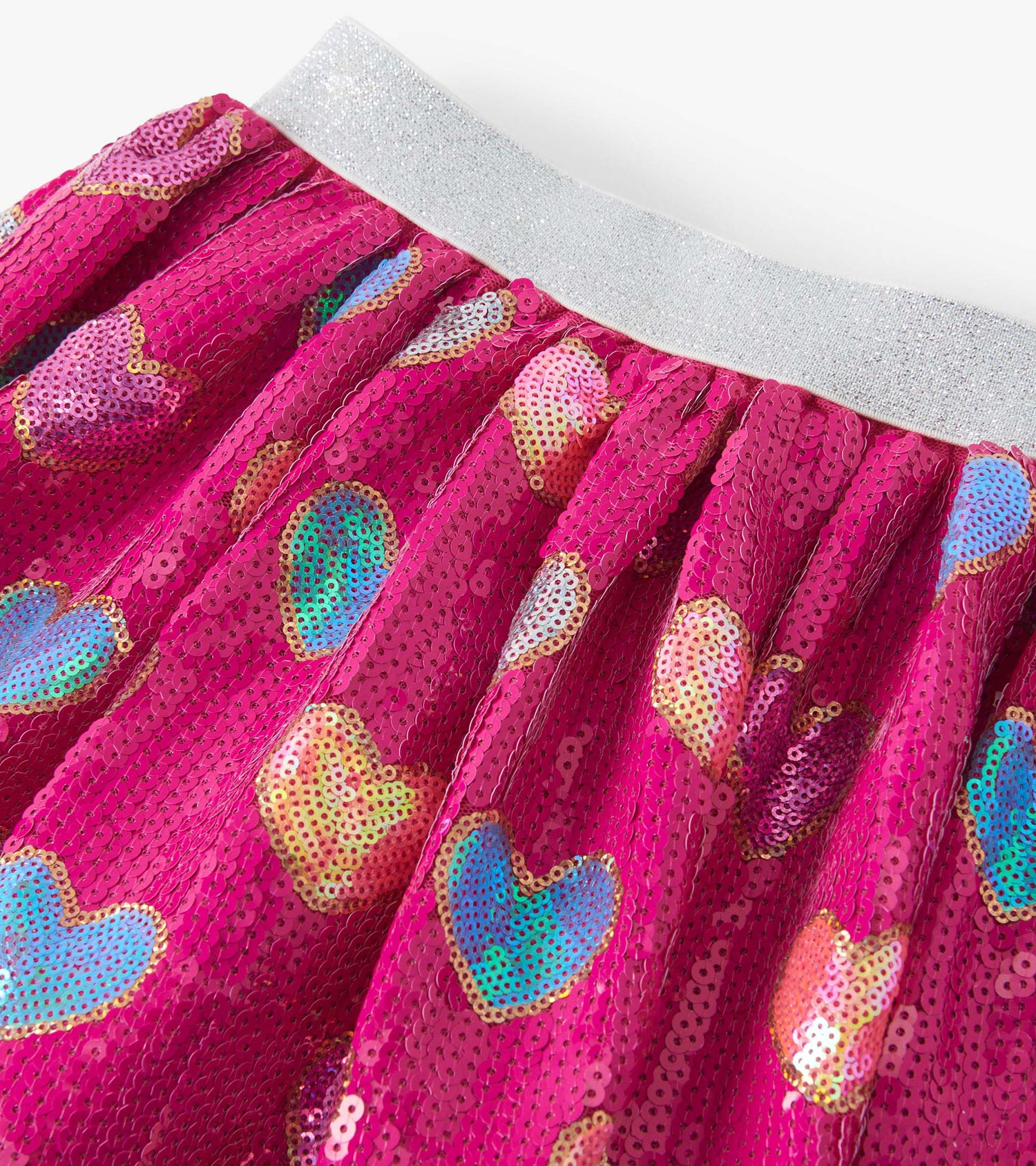 Pink sequin skirt featuring colorful heart patterns and a shiny silver waistband. Ideal for playful, festive occasions.