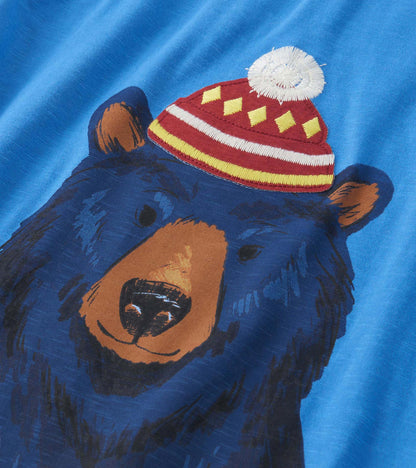 Blue long sleeve tee featuring a graphic of a bear wearing a red and yellow hat with a pom-pom on top.