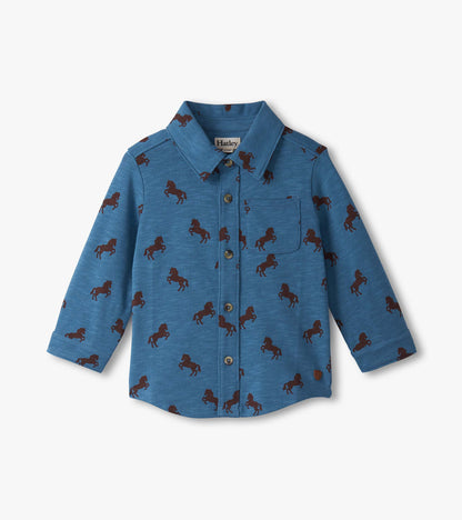 Blue button-down shirt for baby and toddler boys featuring a playful brown horse pattern. Long sleeves and chest pocket.