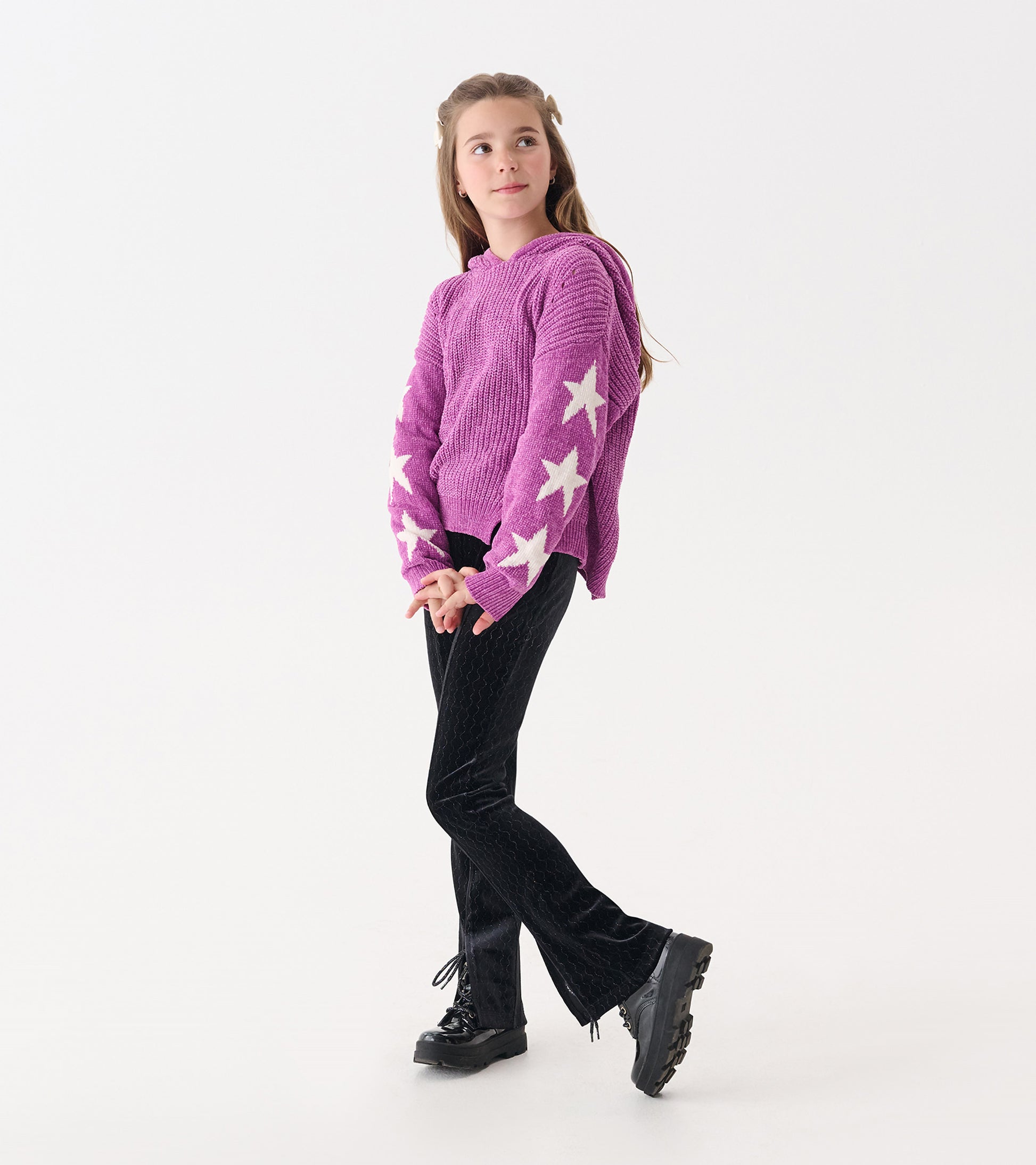 Purple chenille pullover sweater with white star pattern, paired with black pants and boots.