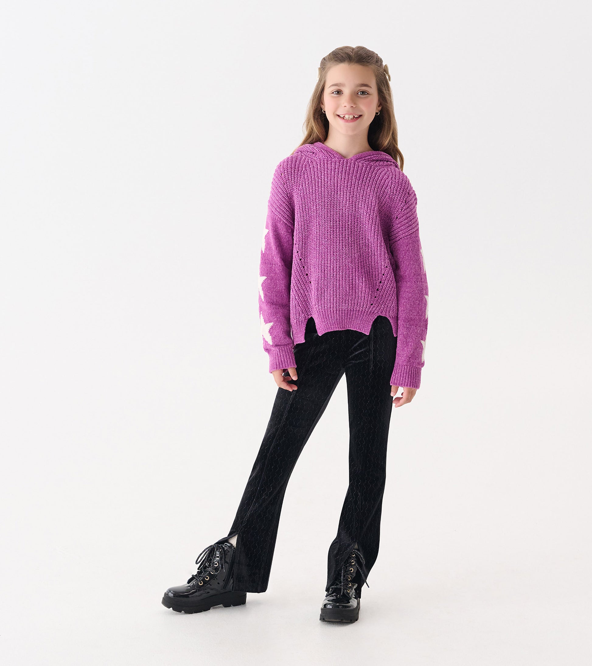 Radiant orchid chenille pullover sweater with star pattern, hood, and side slits, paired with black pants and boots.