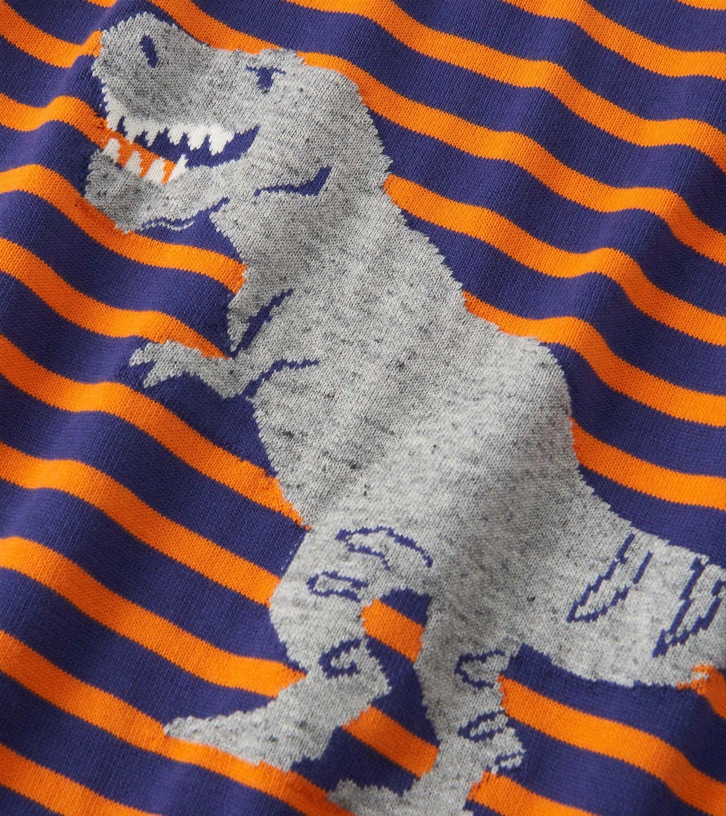 Gray sweater with a dinosaur graphic on a navy and orange striped pattern. Suitable for boys, featuring a raglan design.
