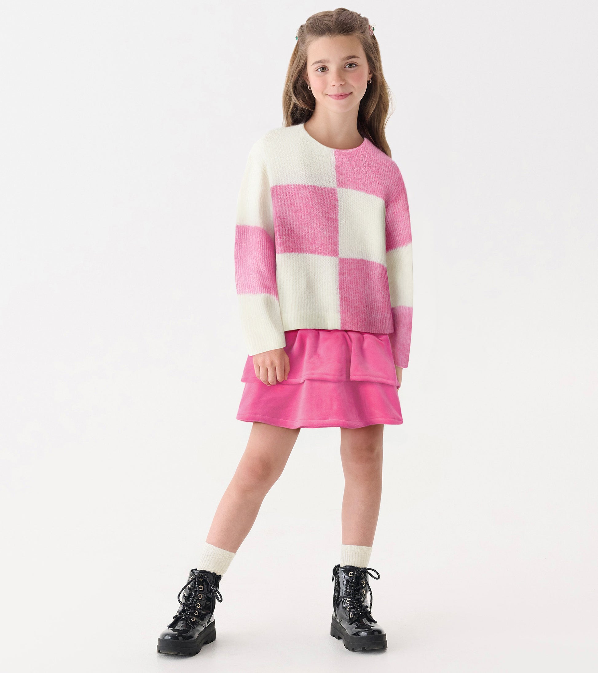 Pink and white check drop shoulder sweater, soft knit, paired with a pink skirt and black boots, suitable for casual wear.