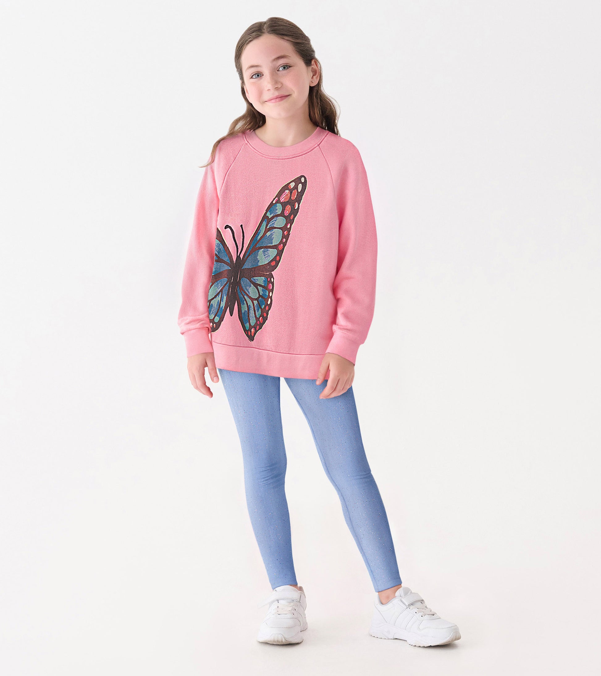 Pink slouchy pullover featuring a large blue butterfly graphic, paired with light blue leggings and white sneakers.