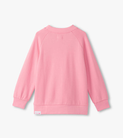 Back view of a slouchy pullover in soft sea pink, featuring long sleeves and a relaxed fit.