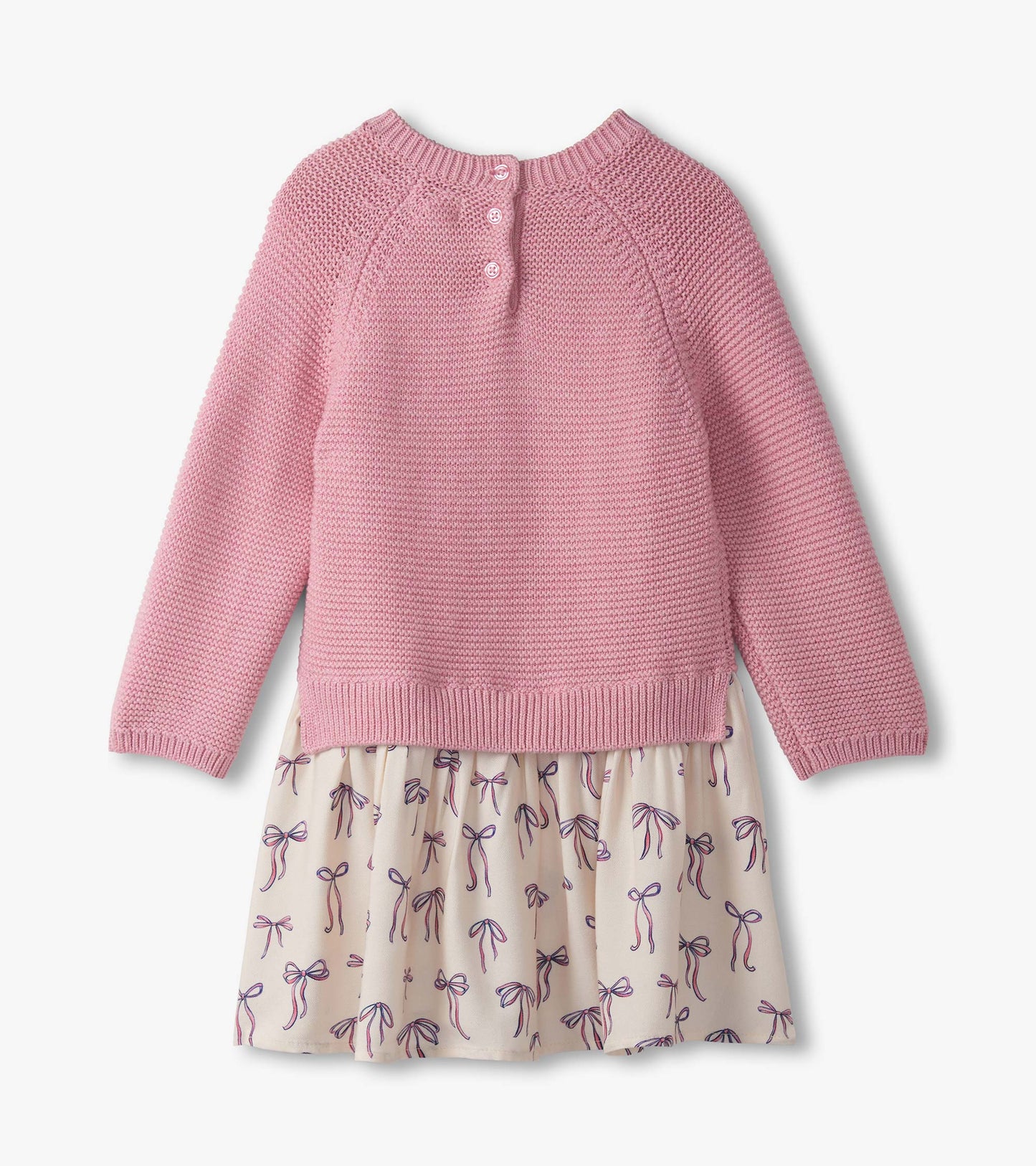 Pink knitted sweater top with button closure, paired with a cream skirt featuring a bow print.