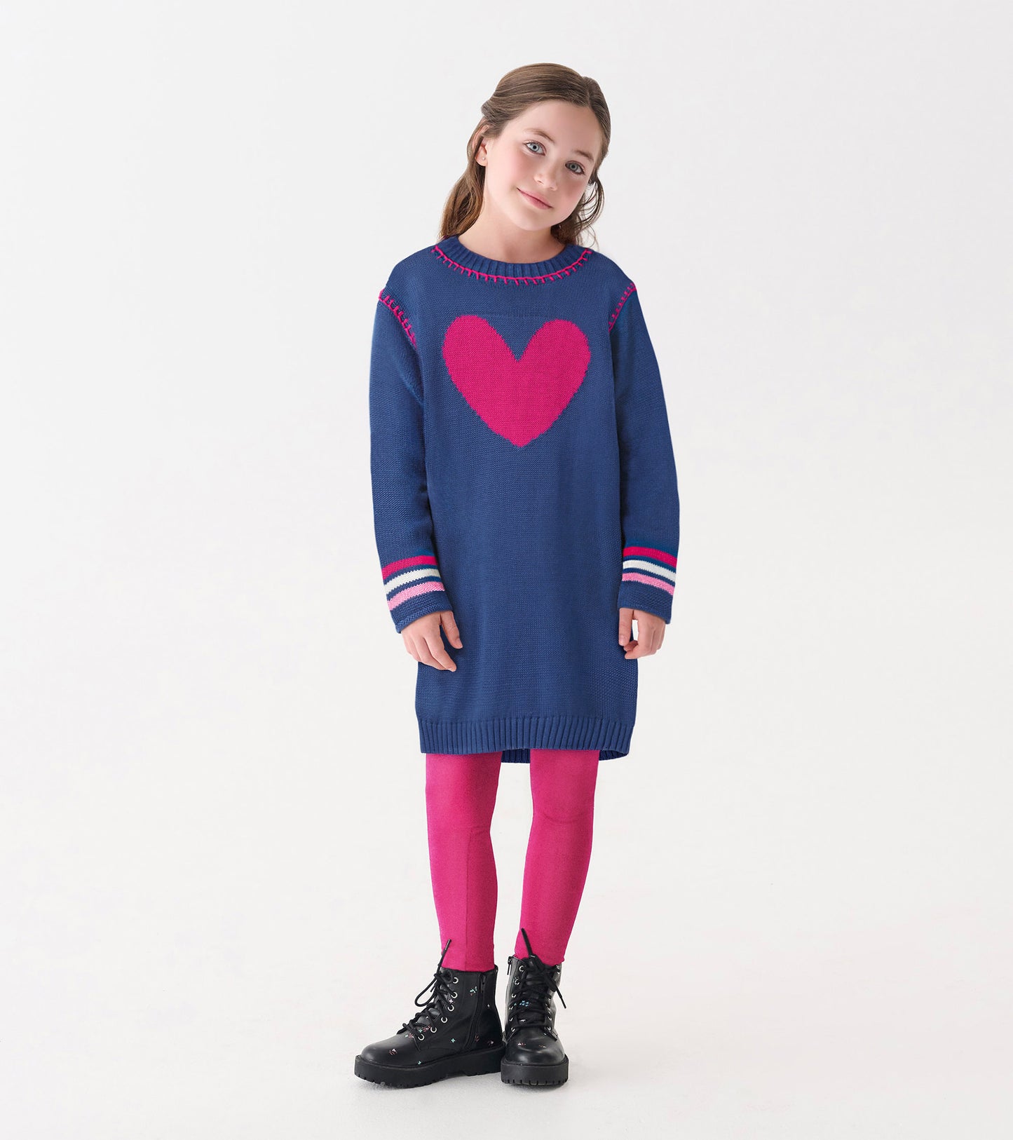 Navy sweater dress with a pink heart design, striped sleeves, and a relaxed fit, paired with pink leggings and black boots.
