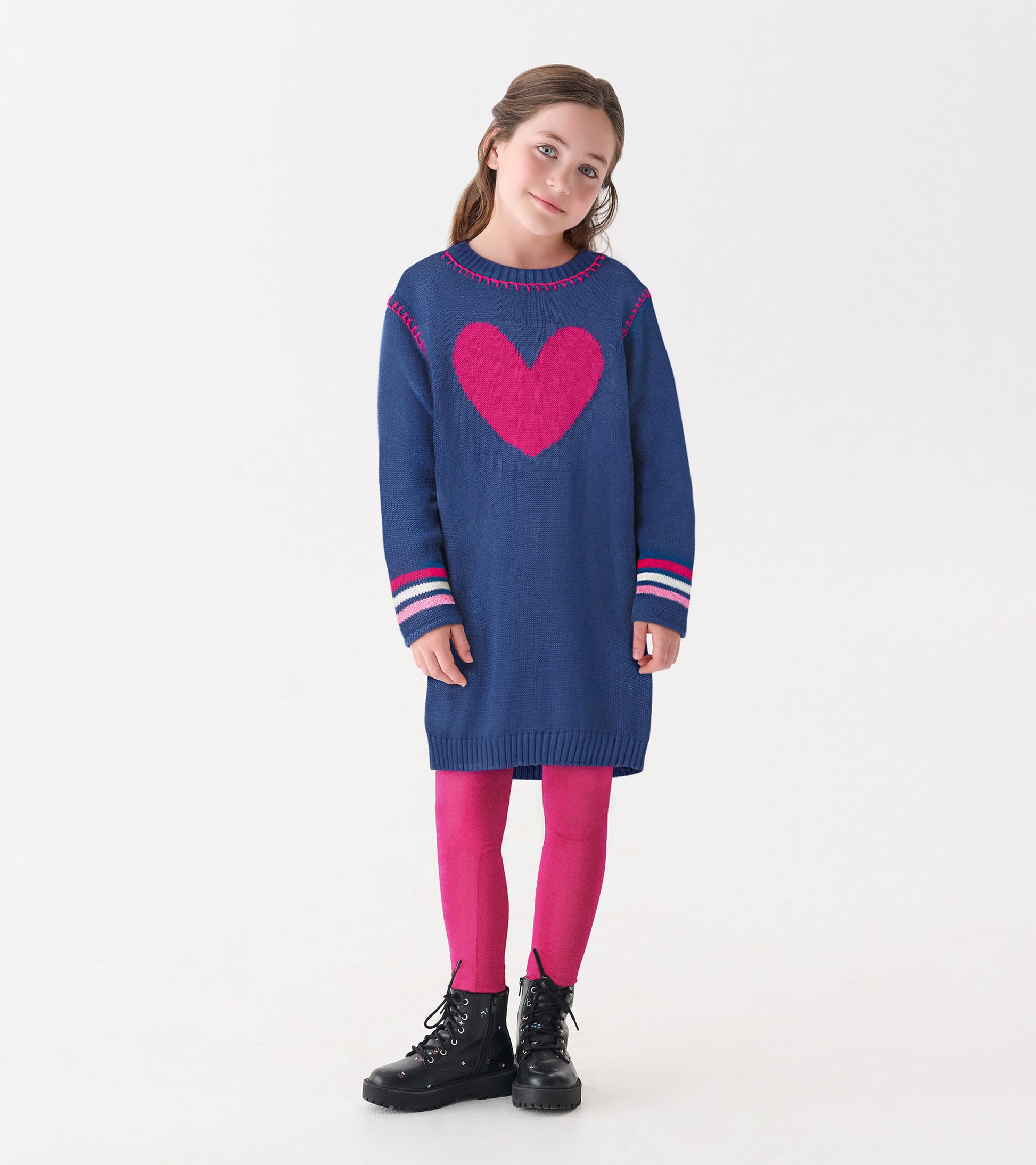 Navy sweater dress with a pink heart design, striped sleeves, and a relaxed fit, paired with pink leggings and black boots.