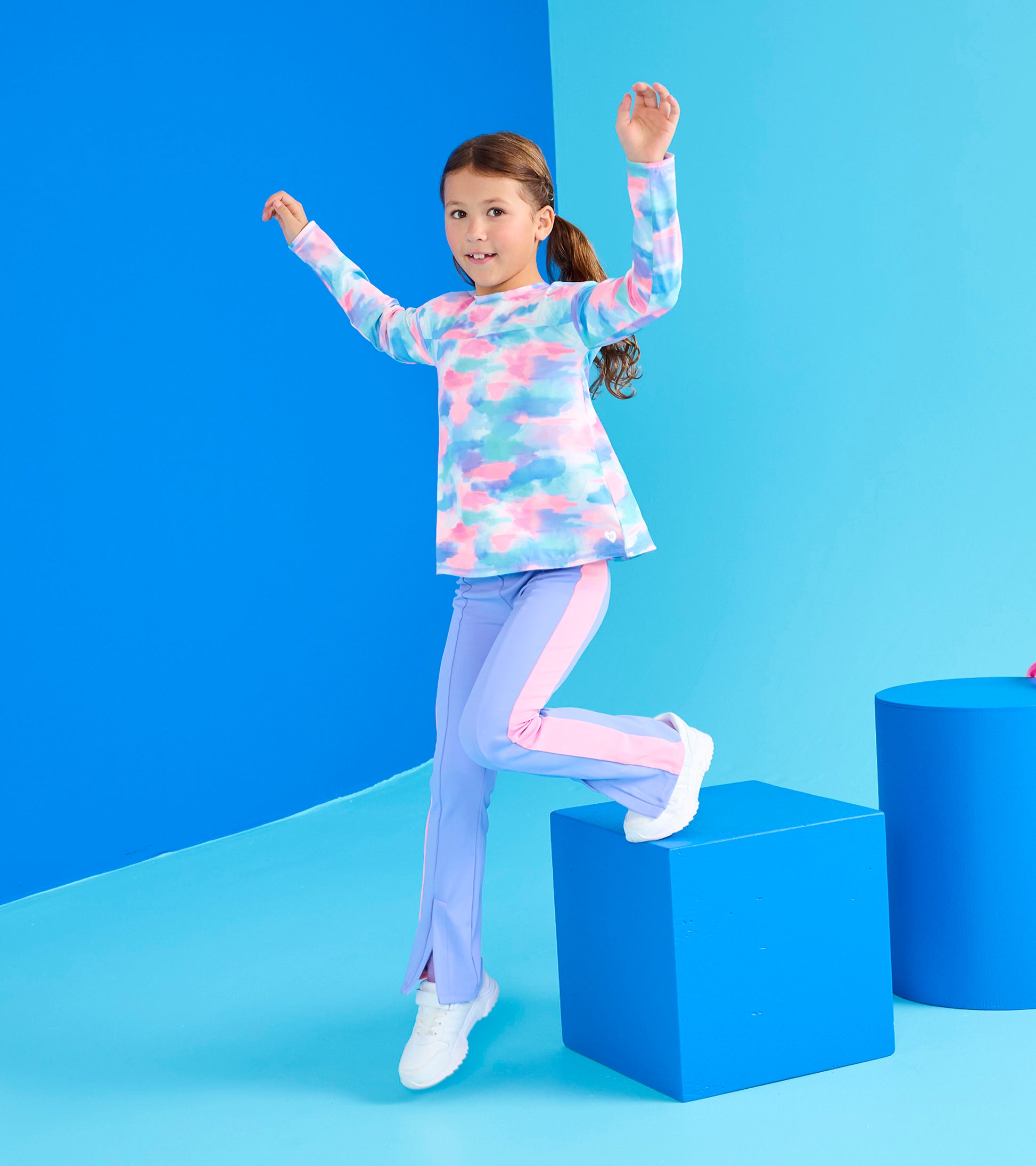Long sleeve swing shirt in pastel colors with a cloud pattern, paired with light purple pants, worn by a girl.
