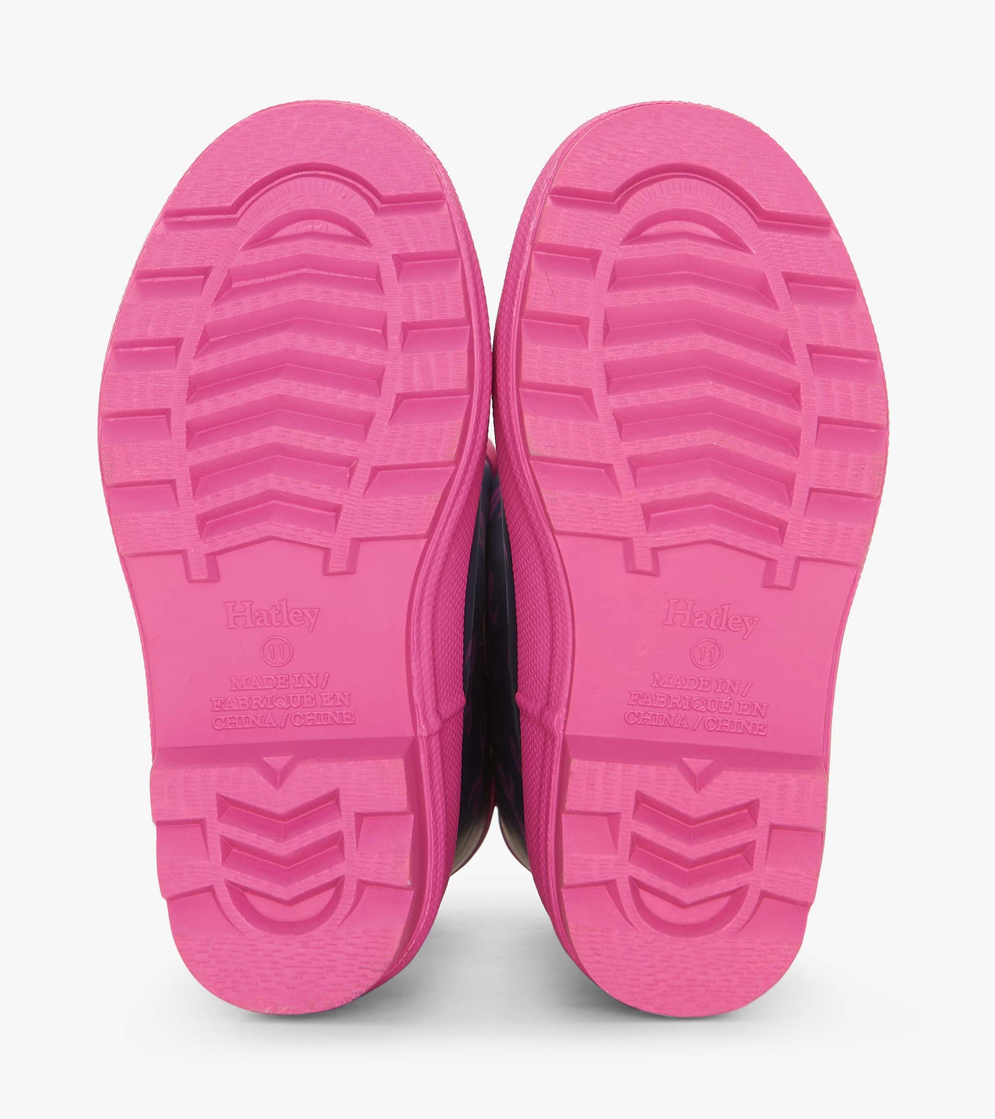 Pink rubber soles of rain boots with textured grip pattern, designed for kids.