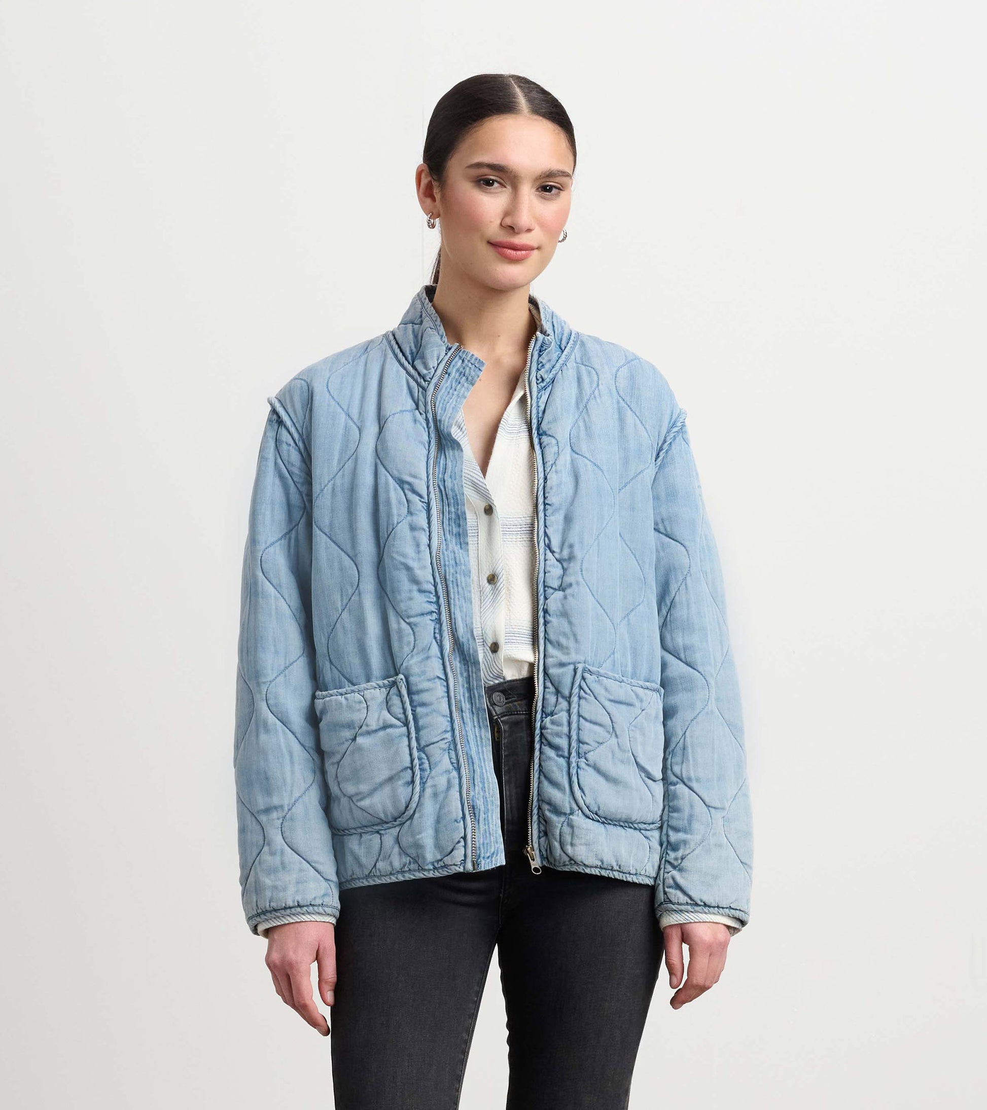 Quilted jacket in washed blue Tencel with a relaxed fit, featuring two front pockets and a stand-up collar.