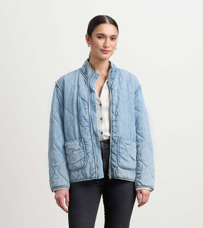 Quilted jacket in washed blue Tencel with a relaxed fit, featuring two front pockets and a stand-up collar.