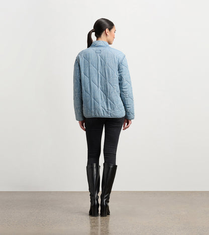 Quilted jacket in washed blue, featuring a collar and a relaxed fit, viewed from the back.