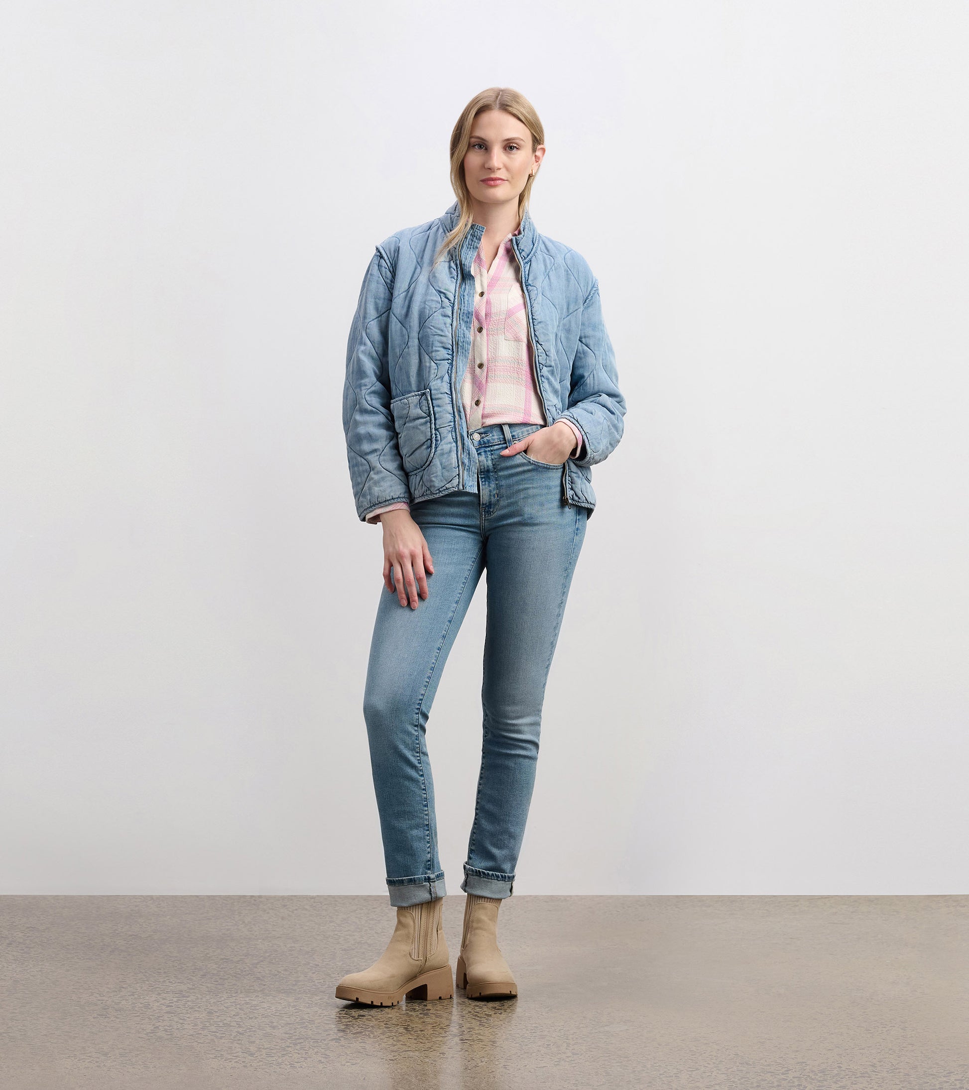 Quilted jacket in washed blue Tencel, featuring a relaxed fit and front pockets, styled with light jeans and beige boots.