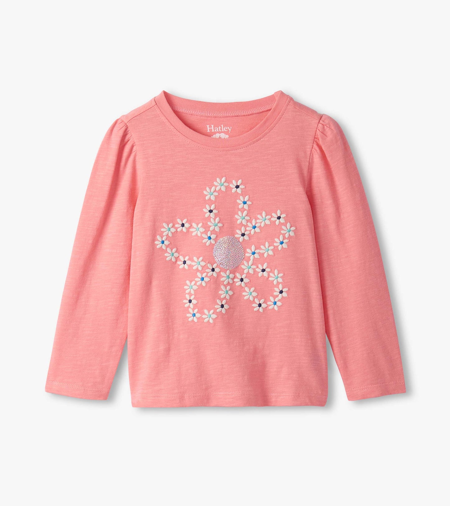 Pink long-sleeve tee featuring an embroidered flower design with colorful accents and puff sleeves.