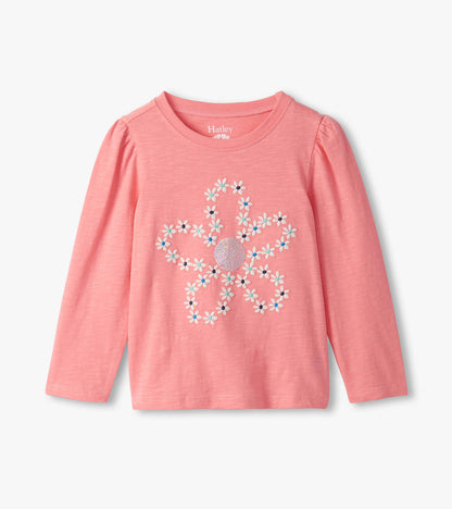 Pink long-sleeve tee featuring an embroidered flower design with colorful accents and puff sleeves.