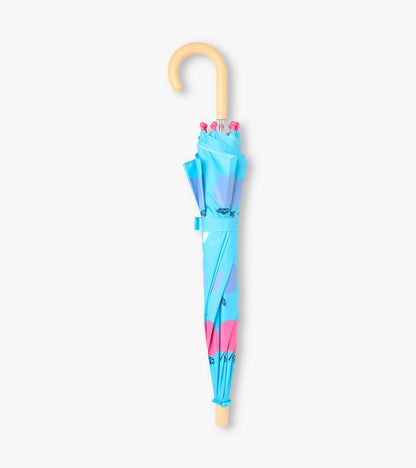 Closed blue kids umbrella with apple print, pink tips, and curved light wood handle