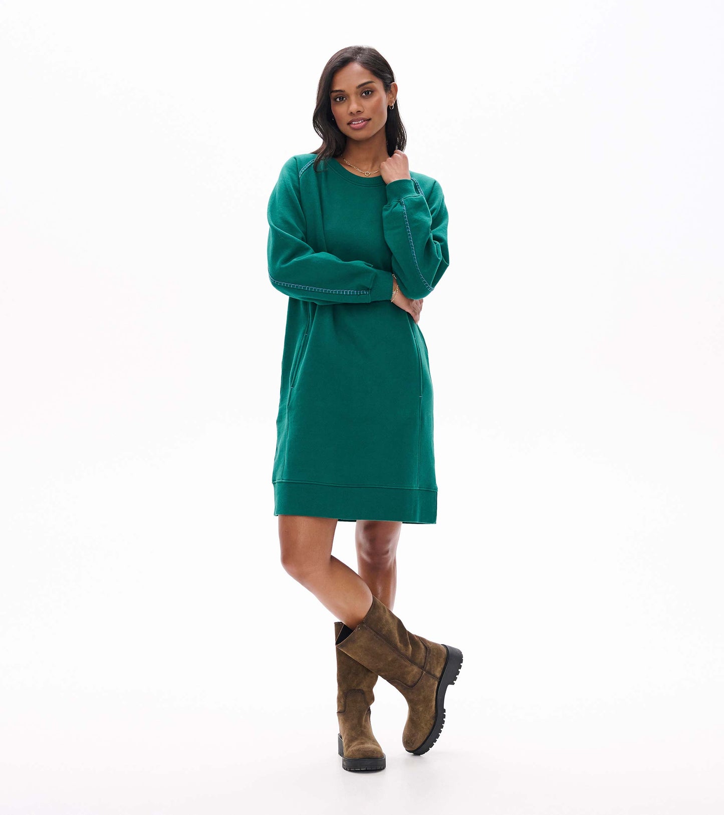 Front view of aventurine green sweatshirt dress styled with brown mid-calf boots